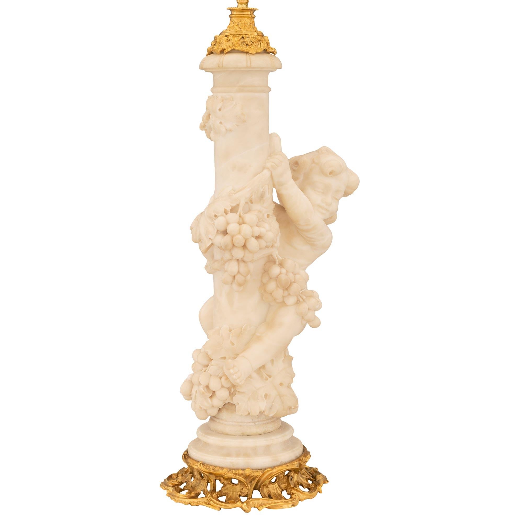 An exceptional and most unique French, 19th century, Louis XV St. Ormolu and Alabaster lamp. The lamp is raised by a beautiful pierced scrolled foliate ormolu base with richly chased designs in a superb satin and burnished finish. The alabaster
