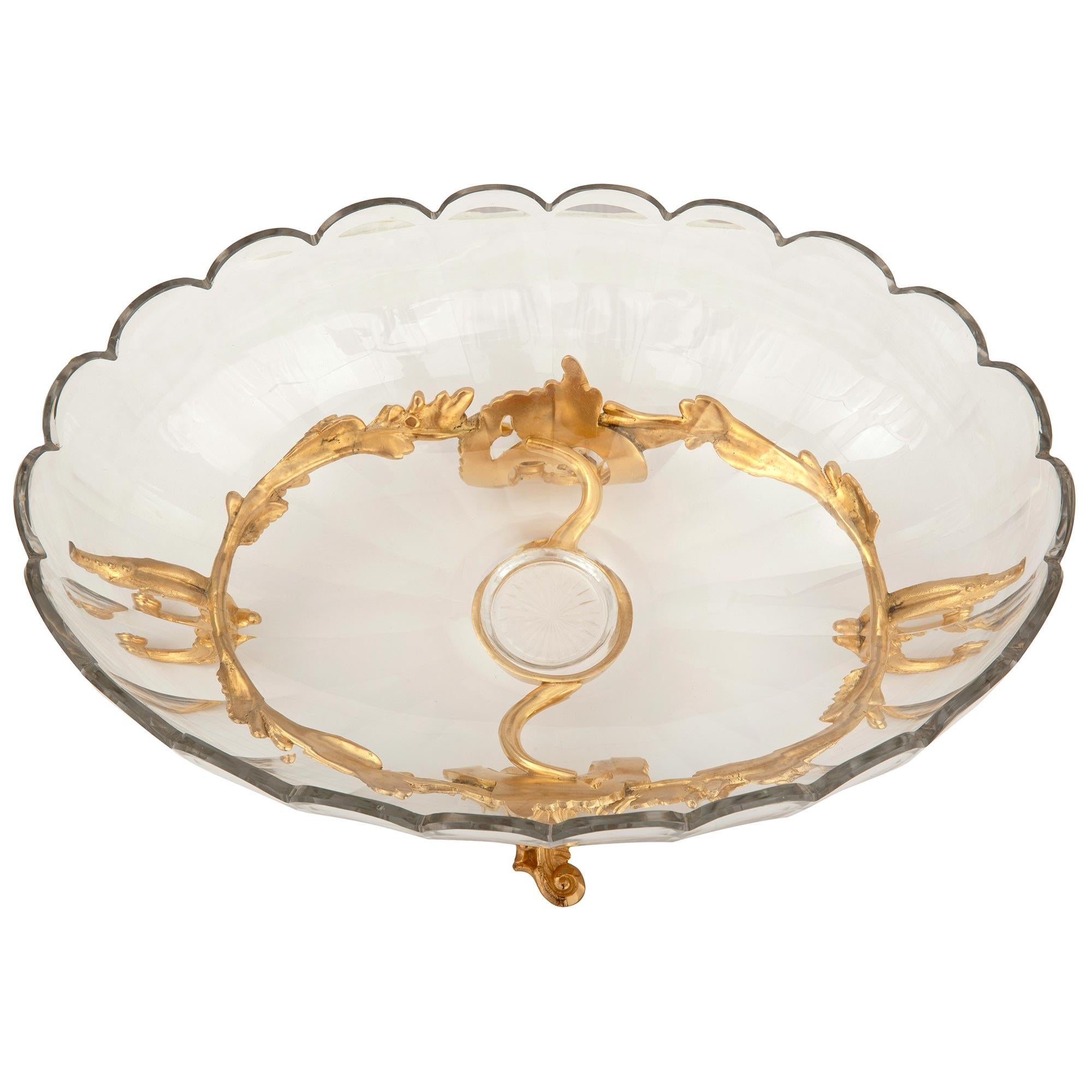 A charming and most elegant French 19th century Louis XV st. ormolu and Baccarat crystal centerpiece. The centerpiece is raised by a beautiful pierced scrolled central reserve with a fine reeded design and striking scrolled foliate legs at each side