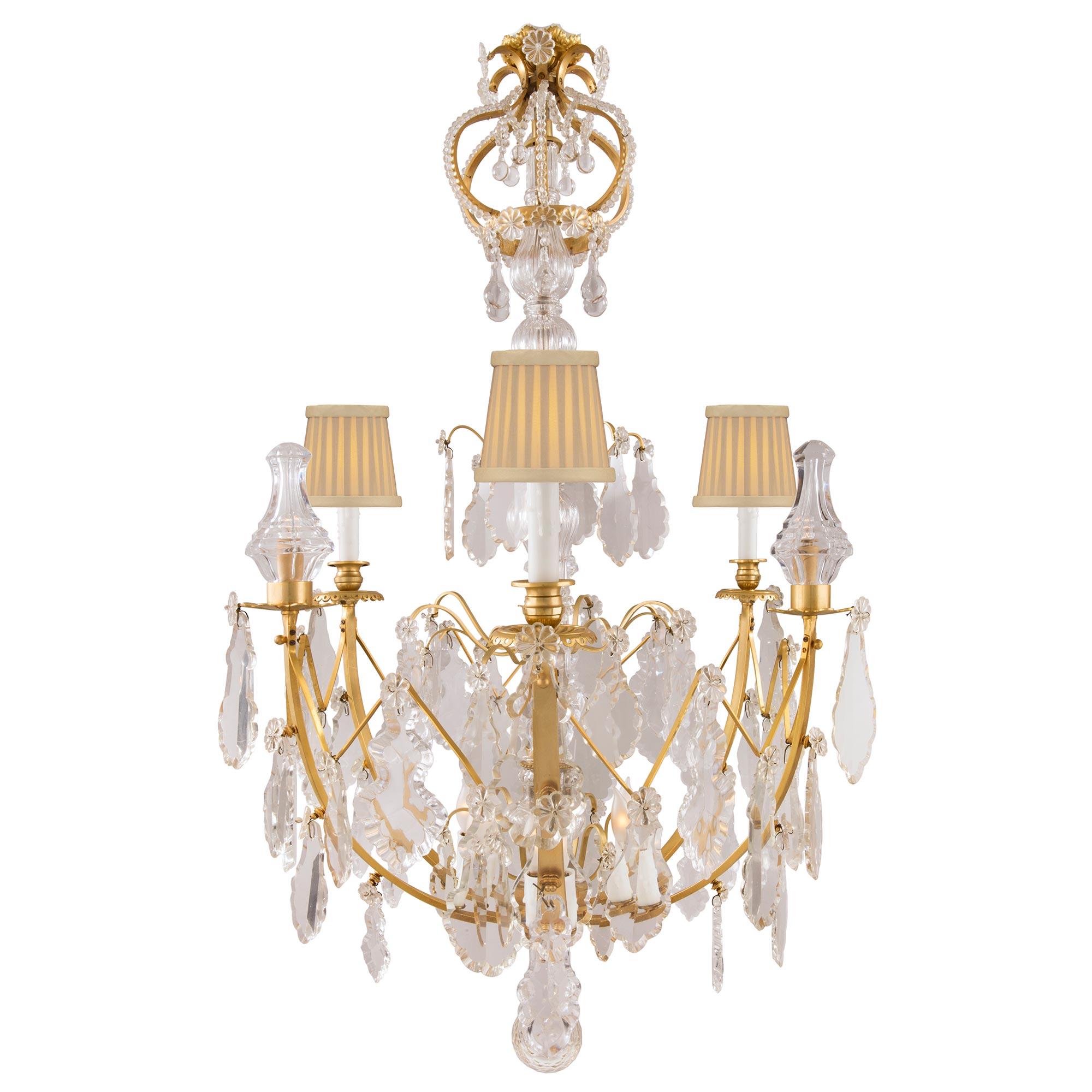 A fine French 19th century Louis XV st. ormolu and crystal twelve light chandelier. The chandelier is centered by an exceptional crystal fut with ormolu sprays and a lower crystal ball pendant. The ormolu arms are decorated with crystals pendants