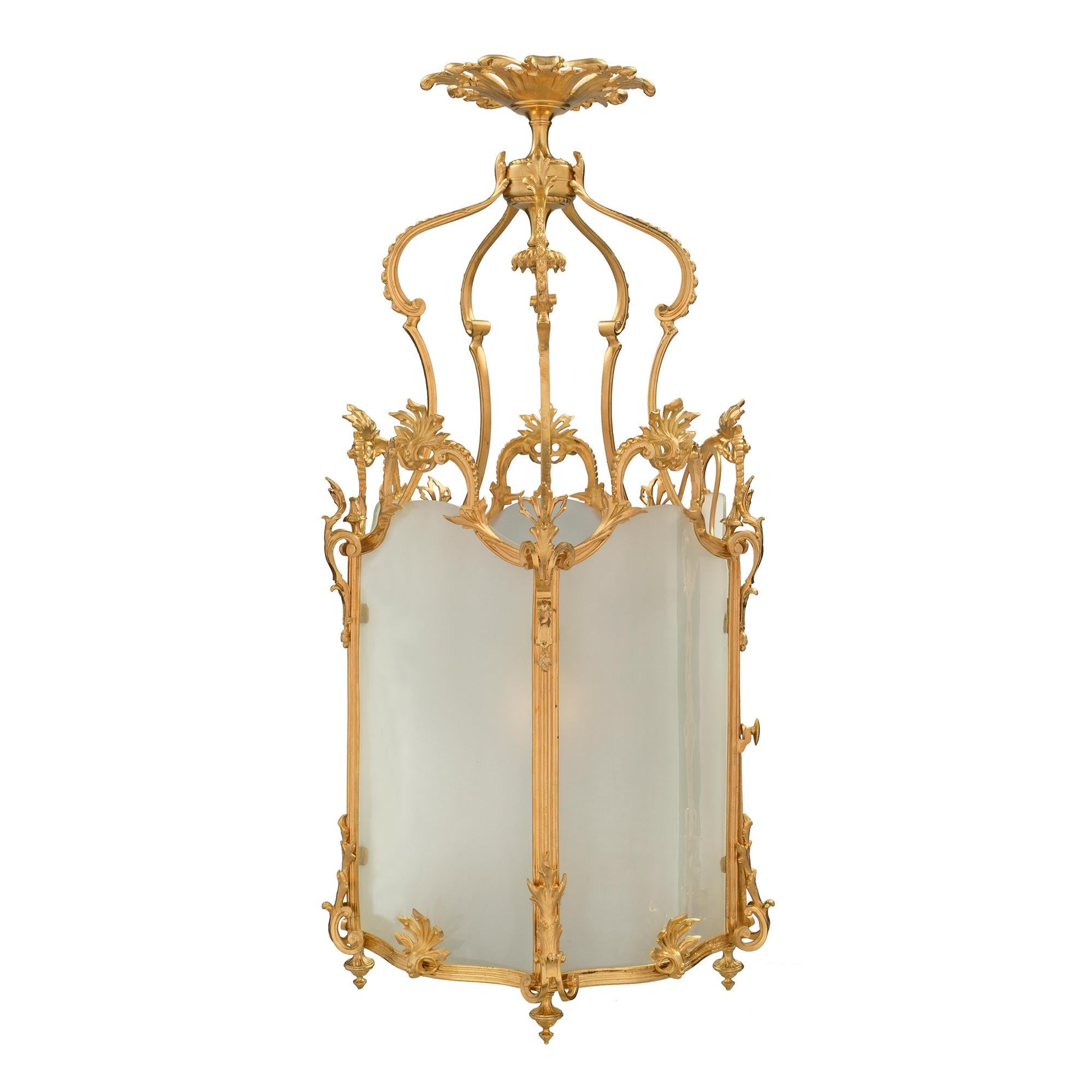 A striking French 19th century Louis XV st. ormolu and frosted glass pentagonal lantern. The lantern displays five topie shaped bottom finial and a beautiful and most unique scalloped shape throughout. The original curved frosted glass sides are