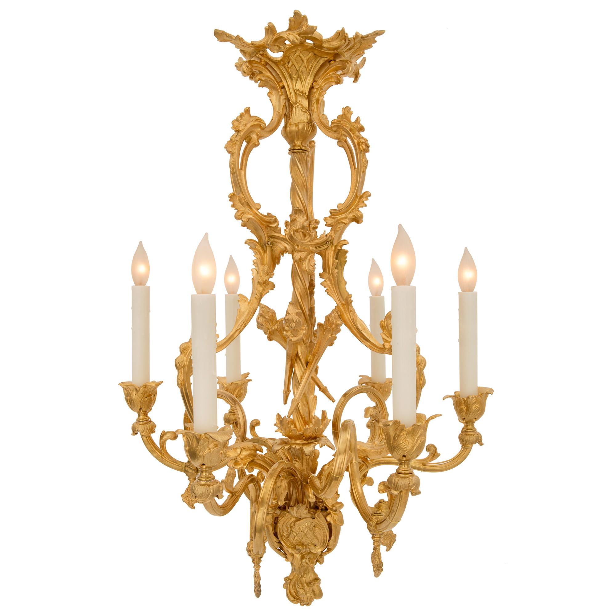 A beautiful French 19th century Louis XV st. ormolu chandelier. The six arm chandelier is centered by an elegant richly chased foliate bottom finial and lovely fitted scrolled crests with a lattice pattern. Each of the six arms displays a stunning