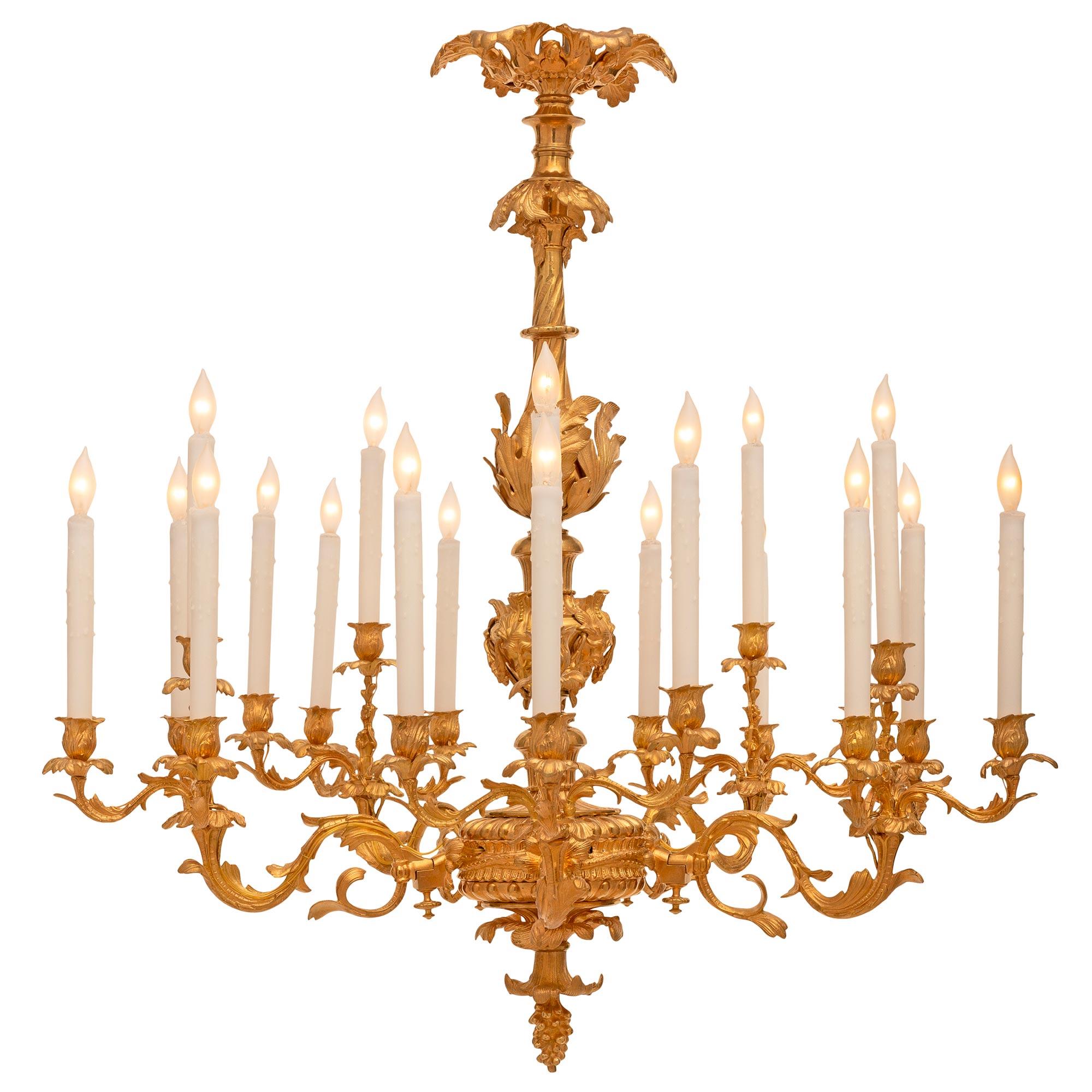 An impressive and high quality French 19th century Louis XV st. ormolu chandelier. The twenty arm chandelier is centered by a beautiful bottom acorn finial below wonderful foliate movements and the reeded central reserve. The arms are grouped into