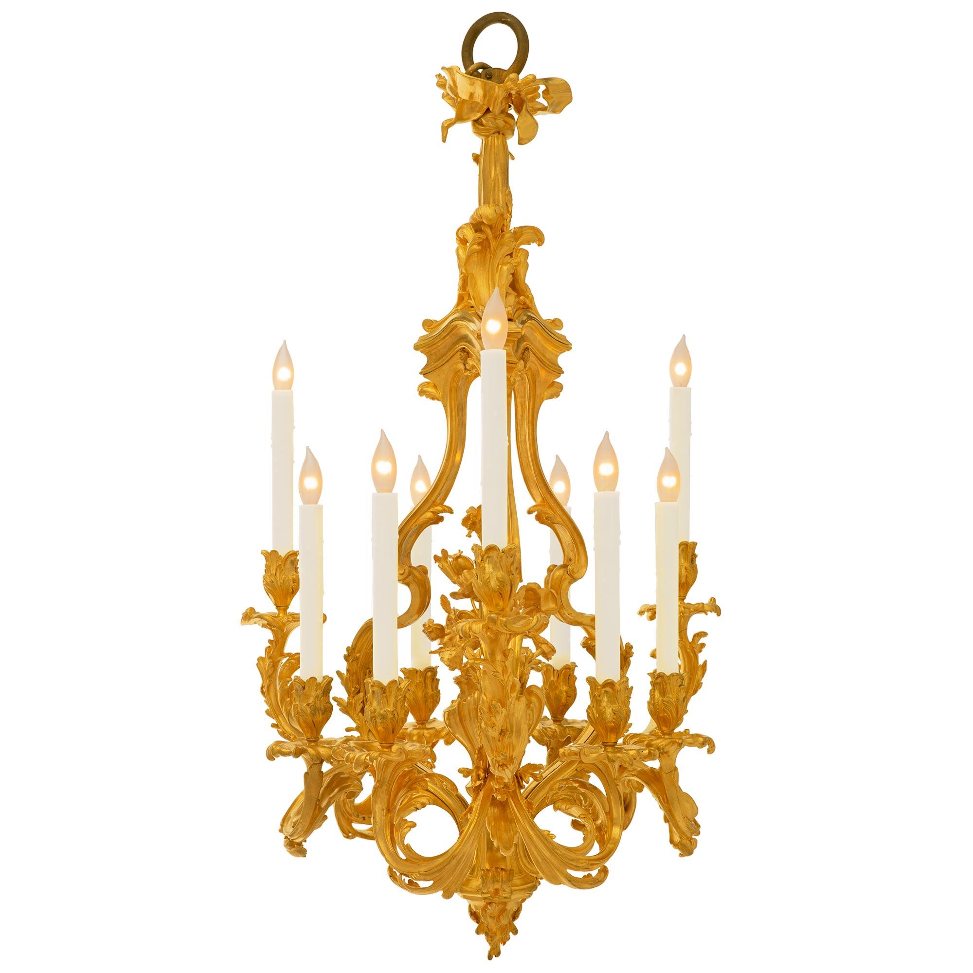 A stunning and extremely decorative French 19th century Louis XV st. ormolu chandelier after a model by Caffieri and attributed to Vian. The nine arm chandelier is centered by a striking bottom foliate finial below the beautiful wonderfully executed
