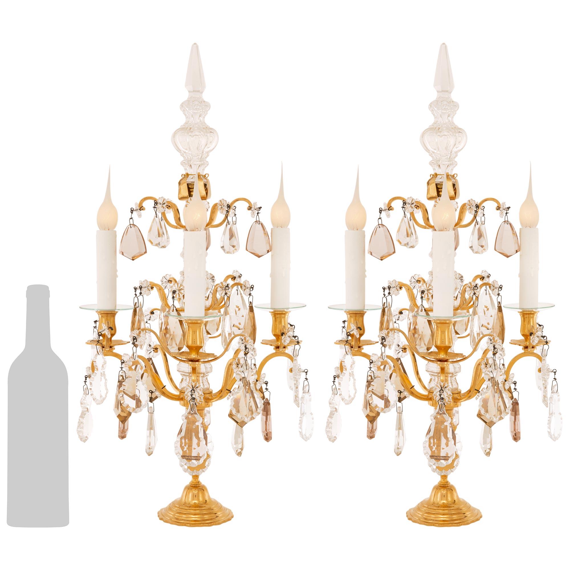 A stunning and most elegant pair of French 19th century Louis XV st. Ormolu, Glass, and Crystal Girandole lamps. Each beautiful four arm Girandole is raised on a circular stepped Ormolu base. Above is the mottled fut that leads to the four scrolled