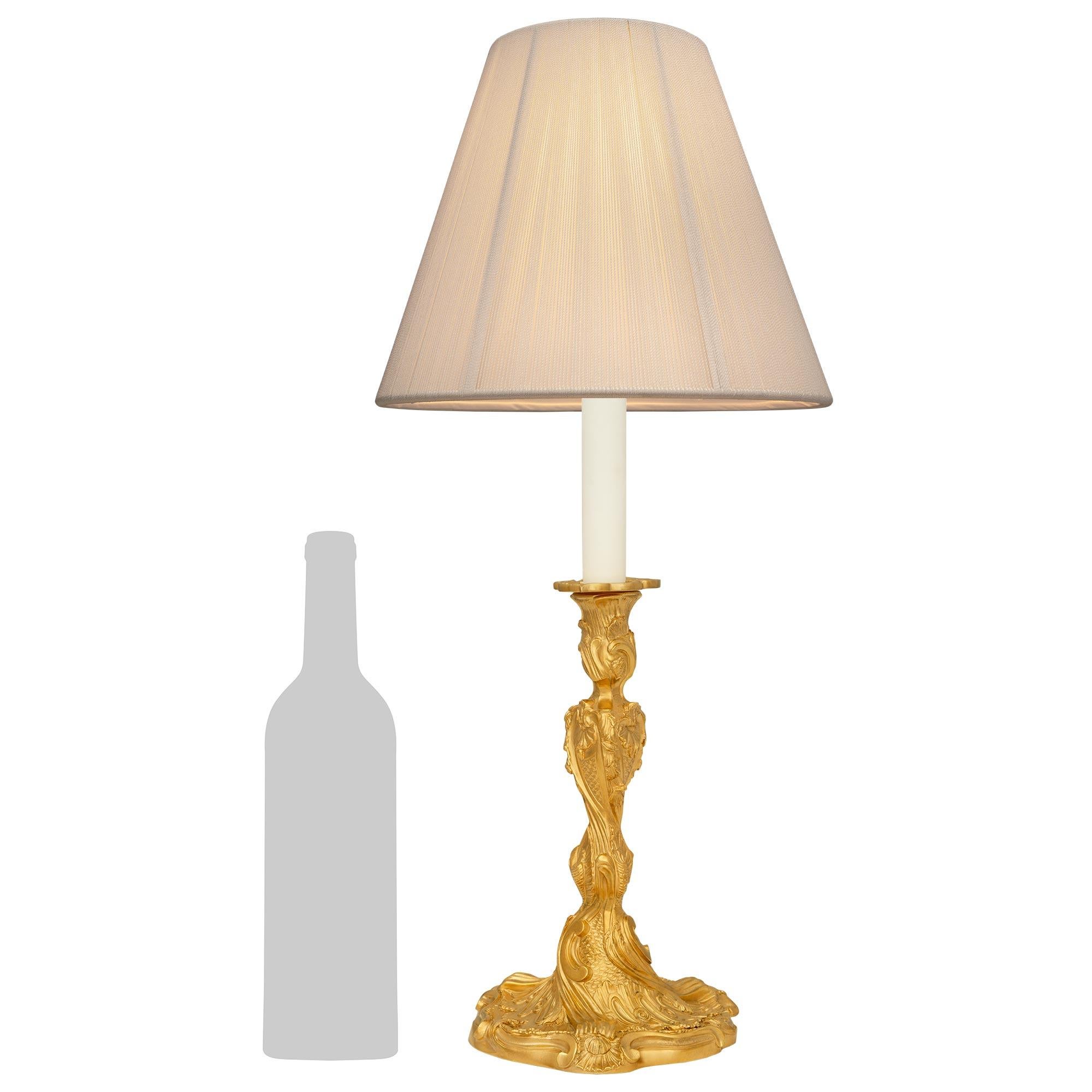 Lámpara de Ormolu de estilo Luis XV francés del siglo XIX, majestuosa y de gran calidad. Este maravilloso candelabro montado en una lámpara se eleva sobre una base de diseño Rocaille con motivos retorcidos y atrevidas bandas reed terminadas en