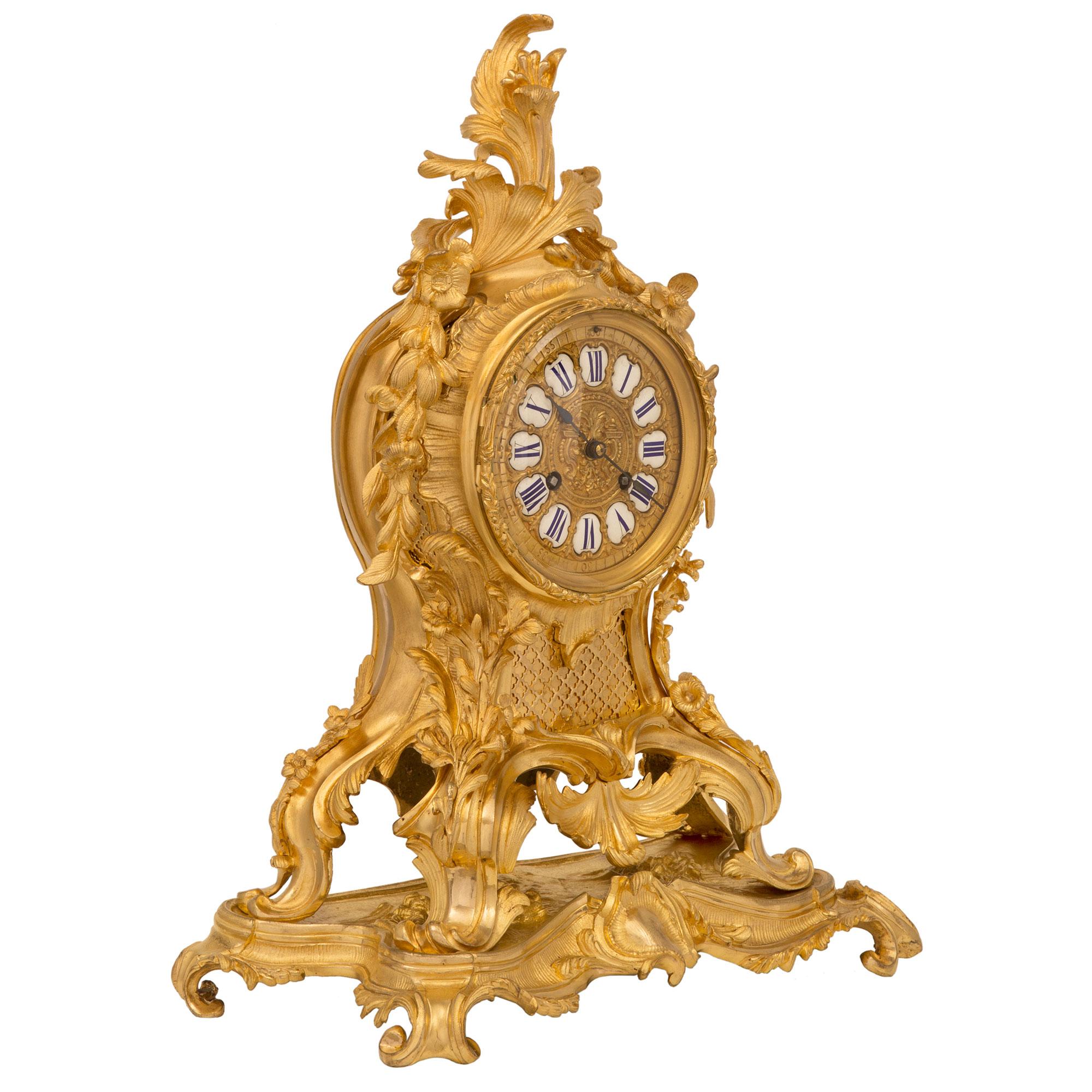 A stunning French mid 19th century Louis XV st. ormolu clock and candelabra garniture set, signed Barrand & Vignon Horlogerie, Paris. The clock is raised by an elegant scrolled Rocaille designed base with a delicate fluted design and a fine central