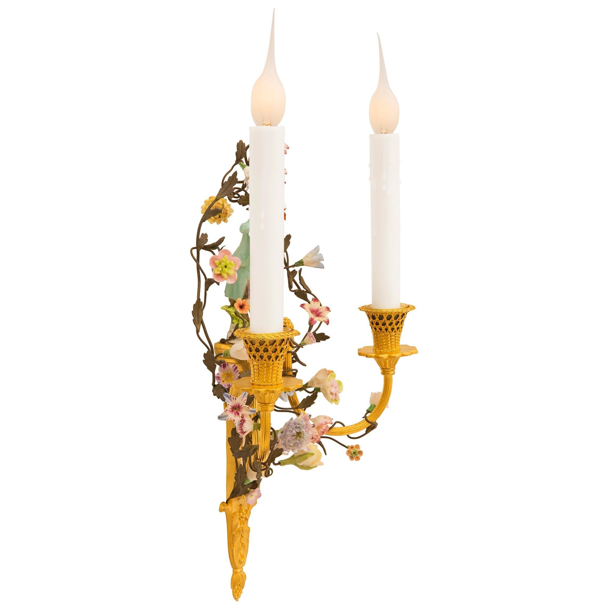 A charming and extremely decorative French 19th century Louis XV st. ormolu, tole and Sèvres Porcelain sconces. Each sconce is centered by an elegant bottom acorn finial below beautiful richly chased scrolled acanthus leaves leading up the elegant