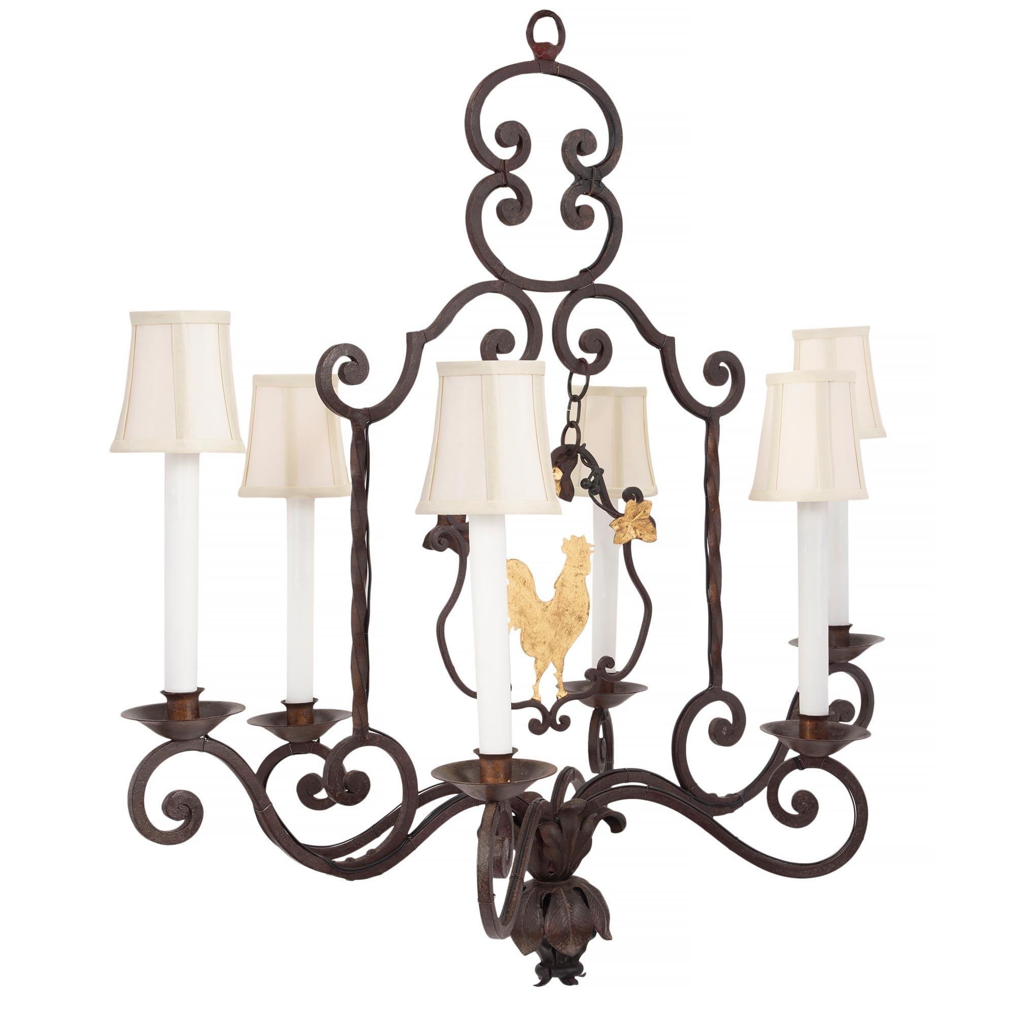 A charming French 19th century Louis XV st. patinated iron and gilt iron six light chandelier. The rectangular shaped chandelier has a wonderful scrolled top design. At the center is a charming hanging decoration of a gilt iron rooster with gilt