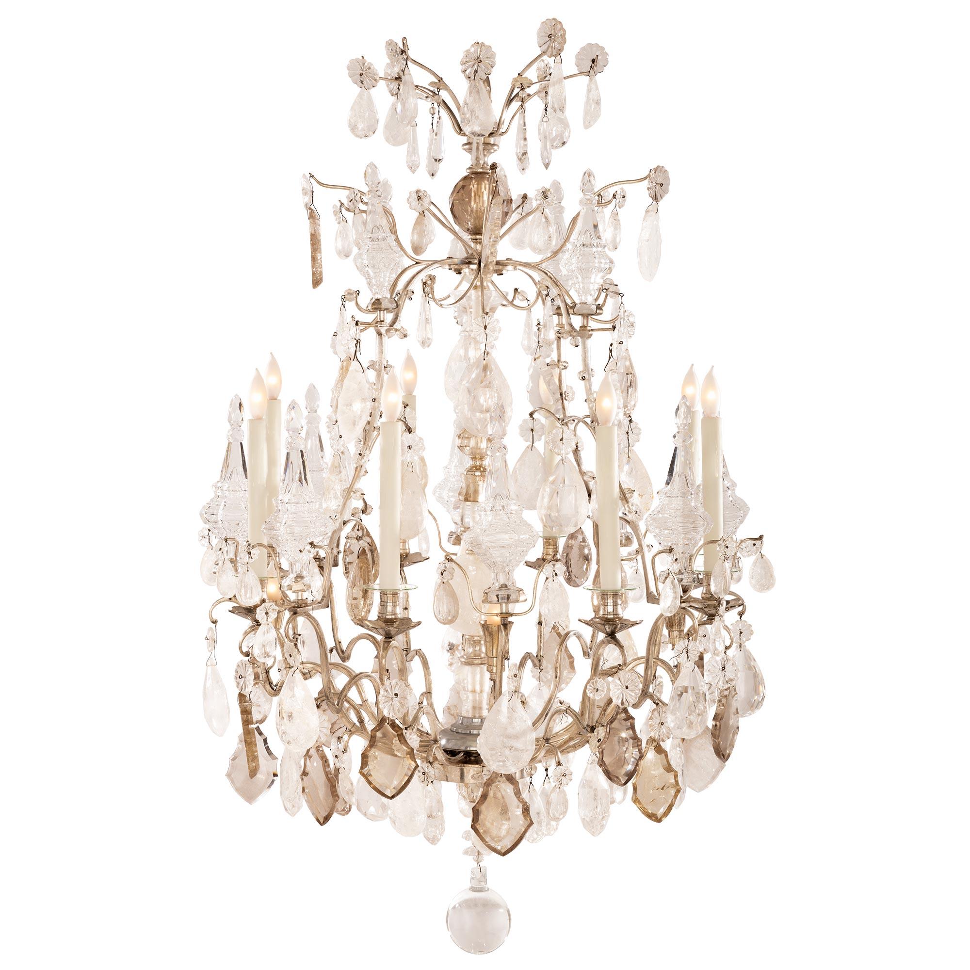 An outstanding and extremely high quality French early 19th century Louis XV st. silvered bronze and rock crystal chandelier. The sixteen arm chandelier is centered by a beautiful solid rock crystal ball below a circular reserve from where the