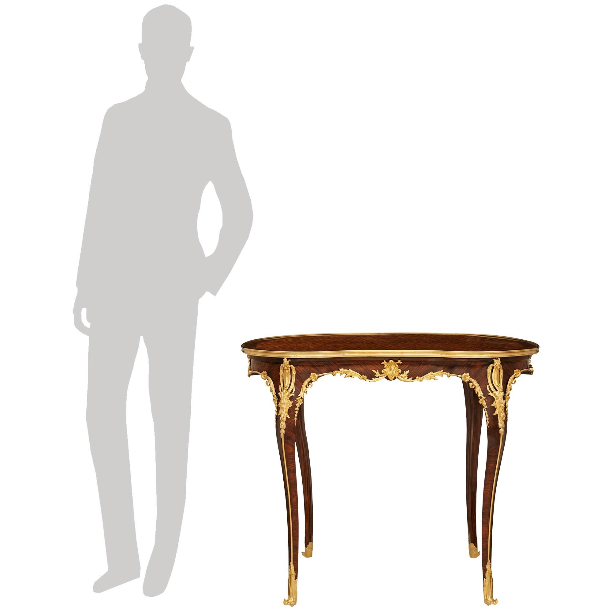 An elegant and high quality French 19th century Louis XV st. Tulipwood, Kingwood and Ormolu side table/desk. This wonderful kidney shaped table is raised on cabriole legs displaying foliate Ormolu sabots with delicate chutes leading up each leg to