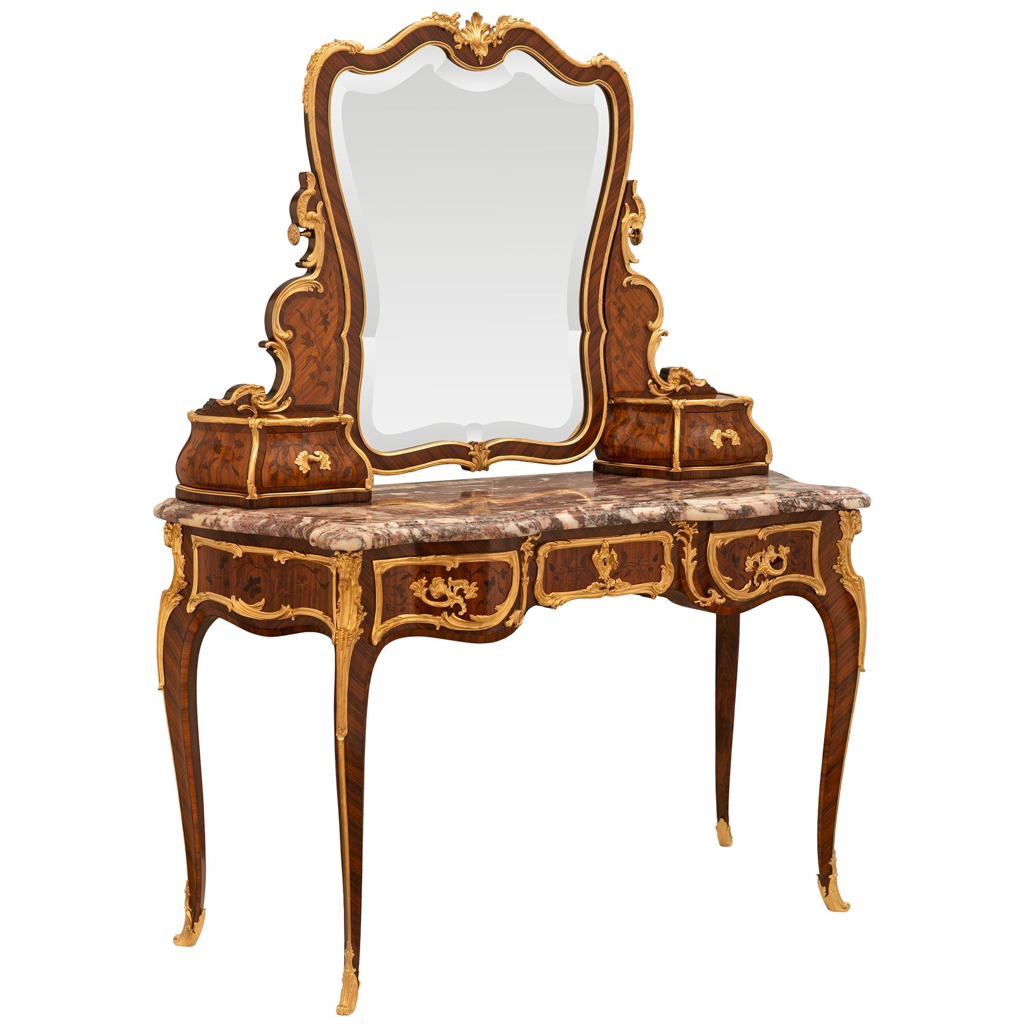 A spectacular and extremely high quality French 19th century Louis XV st. Tulipwood, Kingwood and Ormolu vanity table, attributed to François Linke. The vanity is raised by elegant and slender cabriole legs which are decorated by a top Ormolu mount