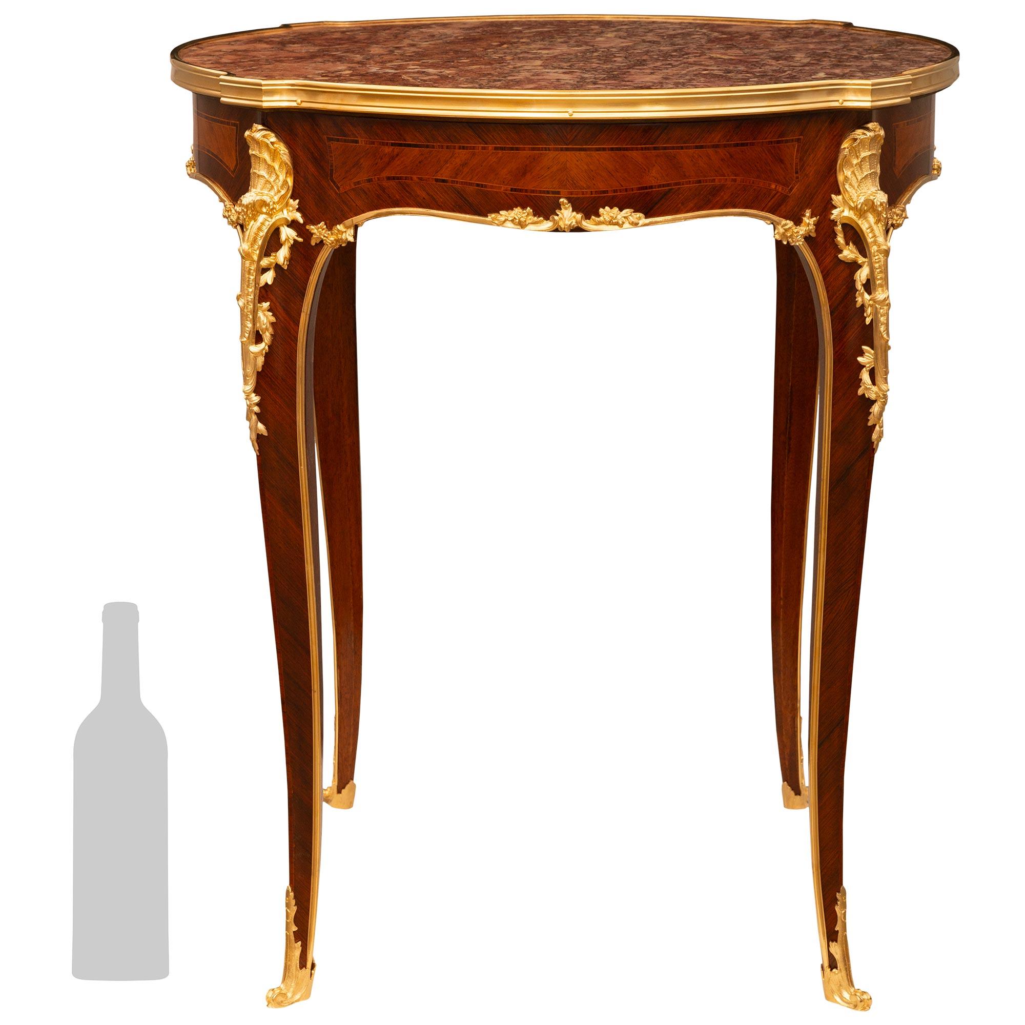 Mesa auxiliar francesa del siglo XIX de estilo Luis XV en madera de tulipán, kingwood, ormolu y mármol Breccia Violette, a la manera de la Maison Krieger, París. Esta impresionante mesa se eleva sobre cuatro patas cónicas cuadradas y esbeltas con