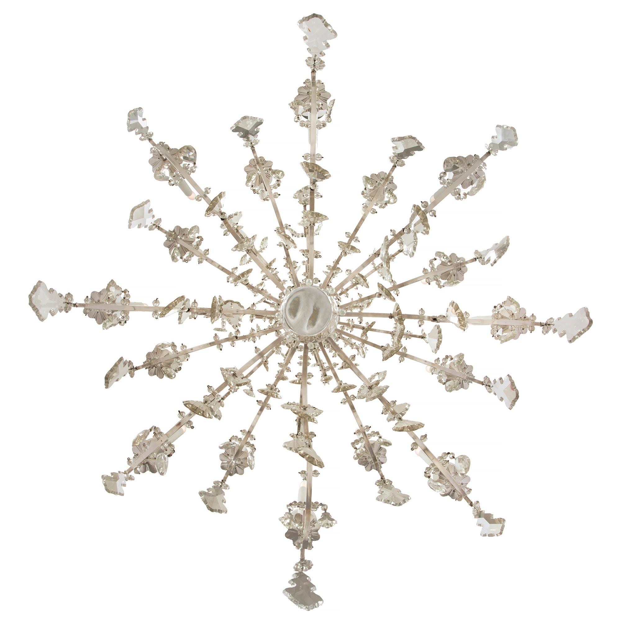 An outstanding French 19th century Louis XV style silvered bronze and Baccarat, attributed, crystal sixteen light two tier chandelier. The chandelier is centred by a bottom solid crystal ball amidst prism shaped cut crystal pendants. The beautiful S
