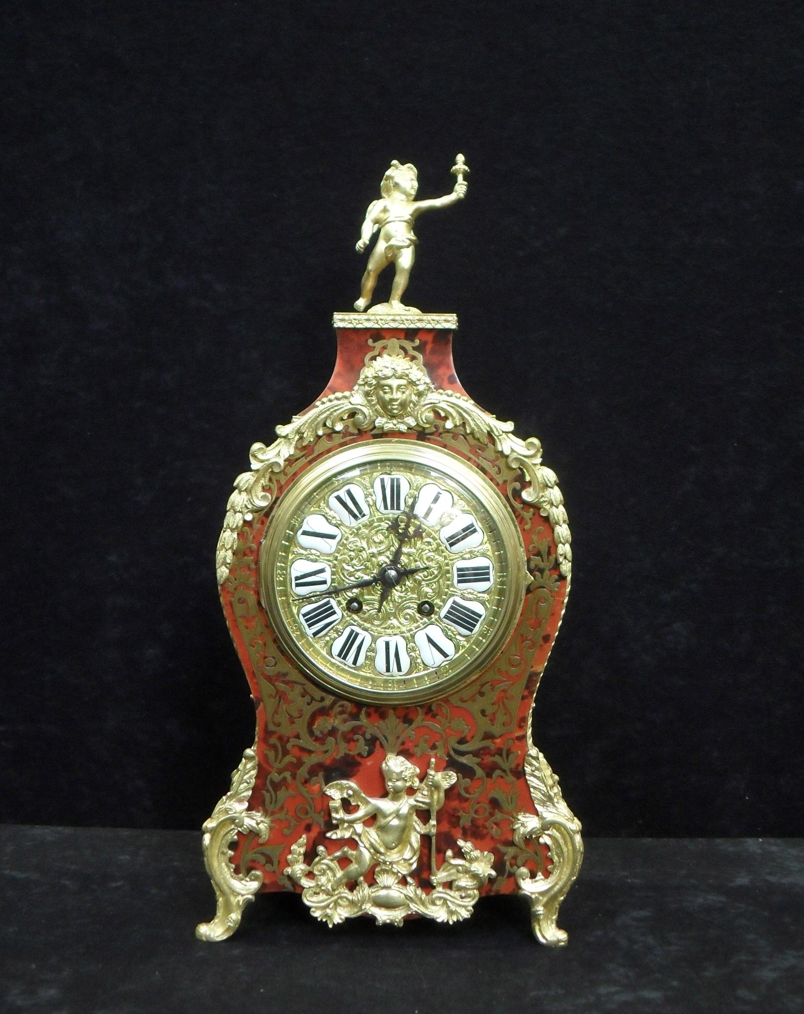 A very good quality French Louis XV style boulle red tortoise shell and brass inlaid mantel clock with ormolu mounts. The clock has a decorative brass dial with white enamel numerals and an eight day French movement which strikes the hours and half