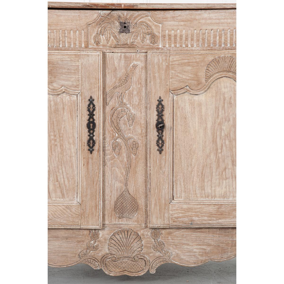 Delight in the detail of this gorgeous buffet! The light pickle-finished wood accentuates the unique carvings and gives the piece an organic essence. The top of this buffet hinges open to reveal an open cavity for storage rather than a drawer. The