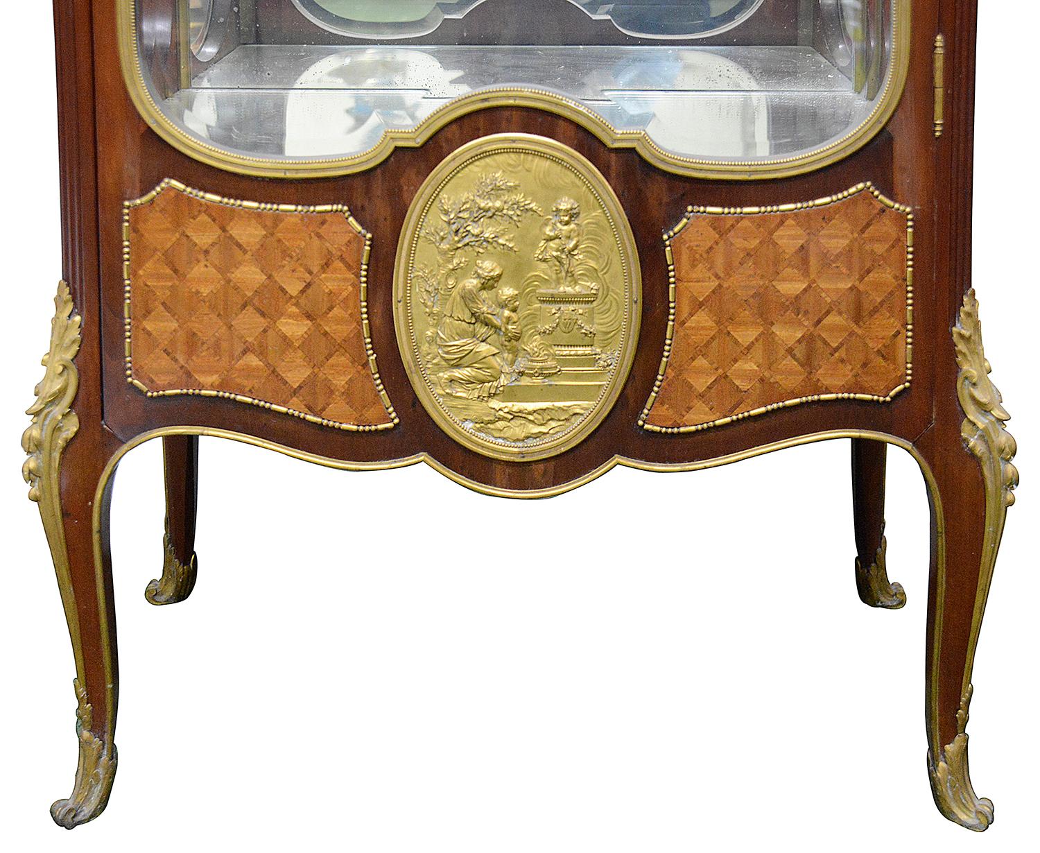 A fine quality late 19th Century French Louis XV style Mahogany vitrine, having its original Fleur De Pecher marble top, gilded ormolu mounts, a single glazed door opening to access adjustable glass shelves within. A classical gilded ormolu oval
