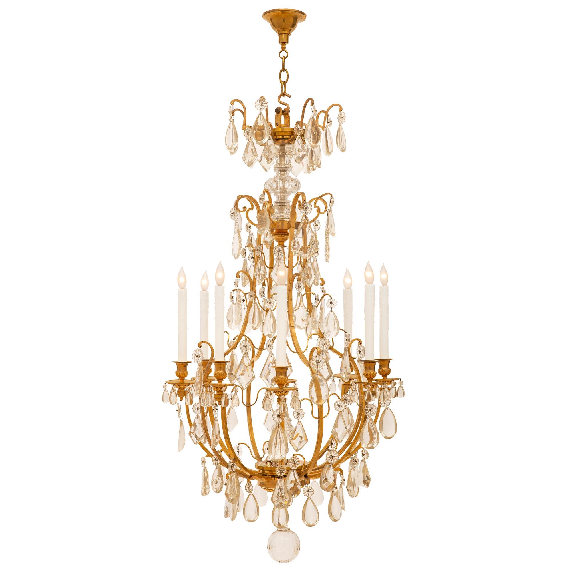 A stunning French 19th century Louis XV st. ormolu and Baccarat crystal eight light chandelier. A crystal ball hangs below the ormolu base with acanthus leaf design and inverted finial. Above is the impressive ormolu open cage adorned with cut