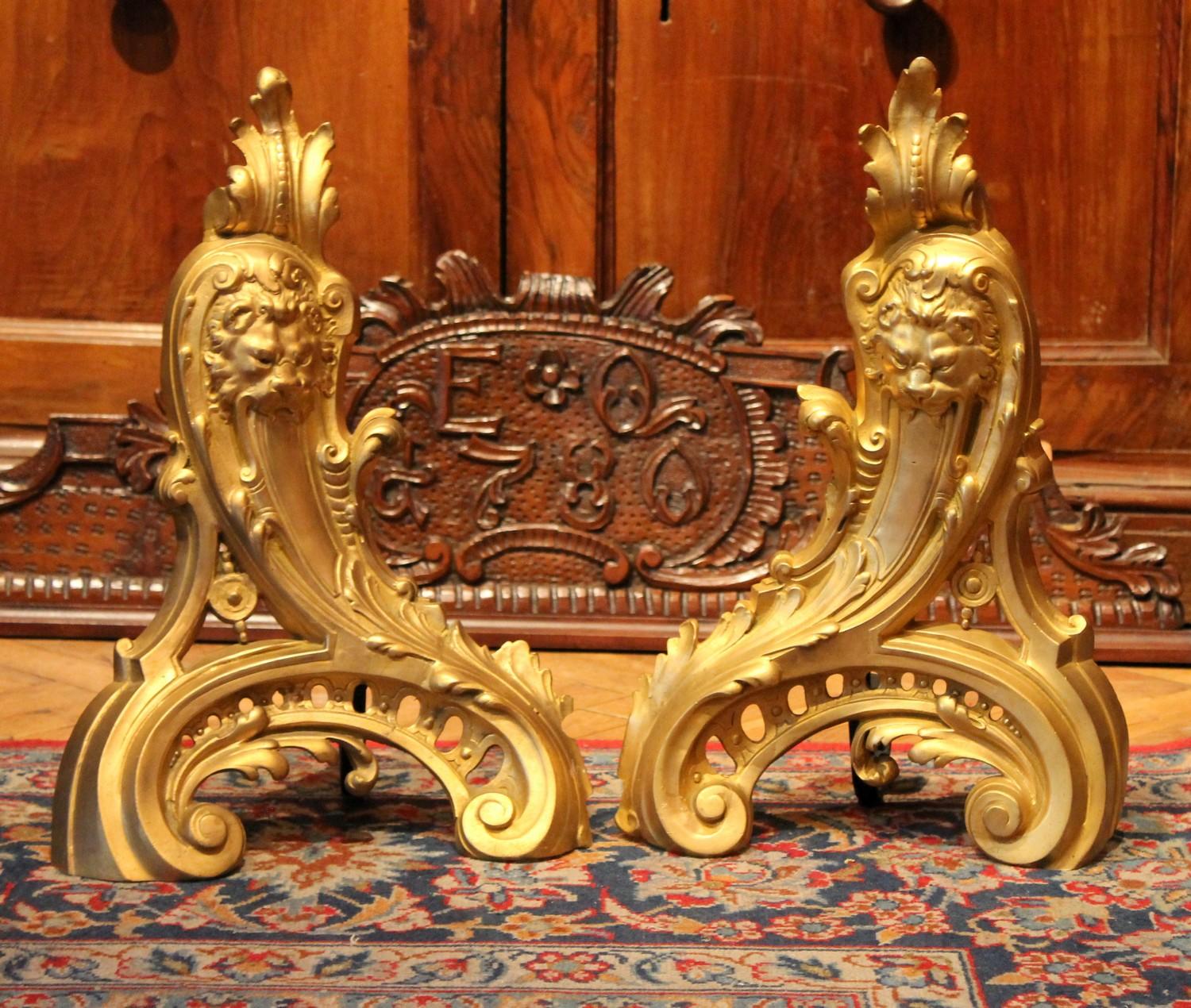 Impressive pair of French Louis XV style finely chiseled gilt bronze andirons. These Rocaille ormolu chenets are extremely decorative each depicting a lion’s head crafted in relief surrounded by rich Rococo decorations such as acanthus leaves,