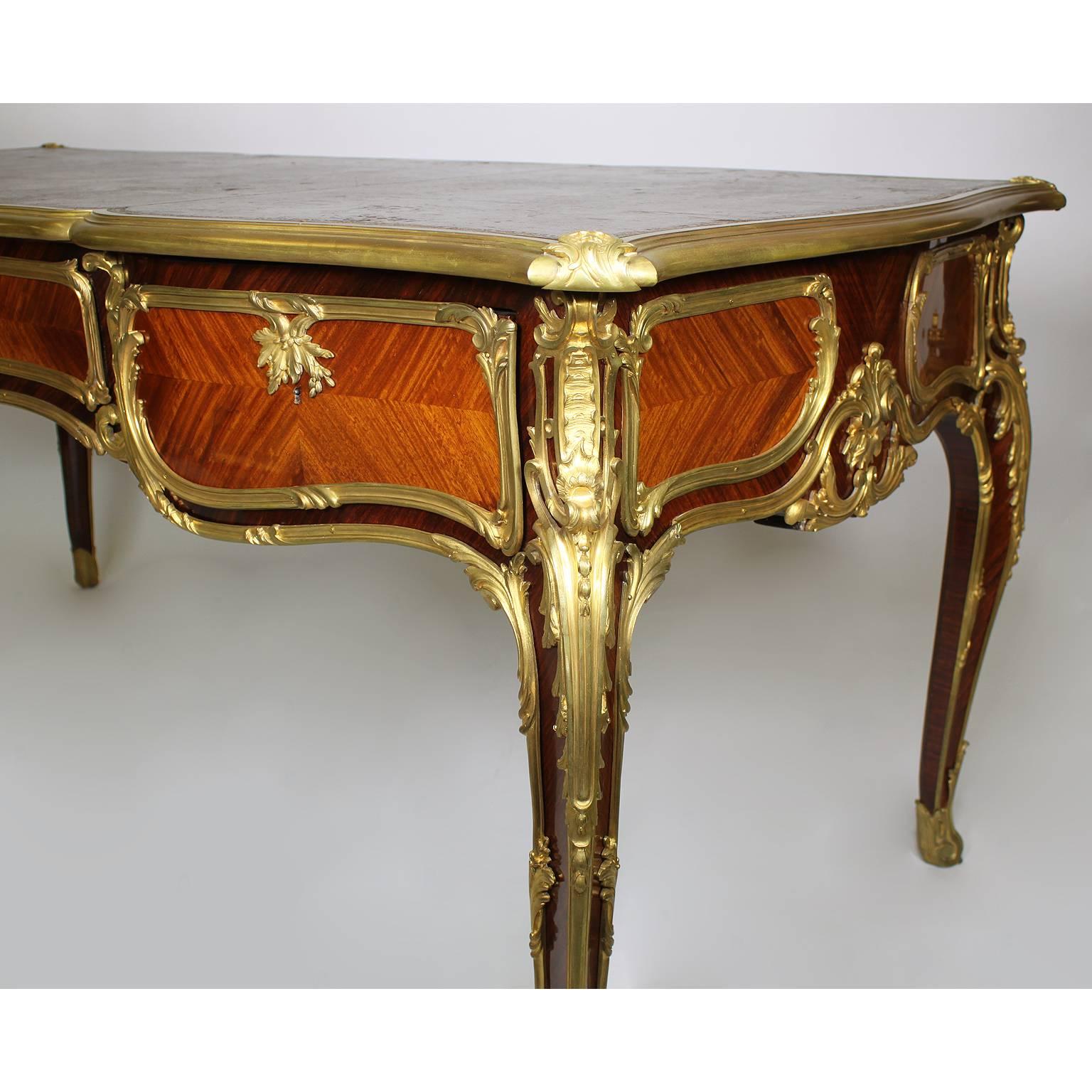 A fine and large French 19th century Louis XV style gilt bronze-mounted kingwood and tulipwood bureau plat (Desk or writing table). The shaped rectangular top inset with a tooled leather writing panel and fitted with three drawers to the undulating