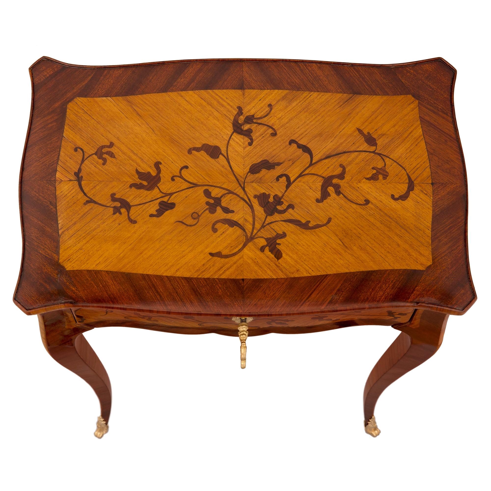 A charming French 19th century Louis XV st. kingwood, tulipwood and ormolu side table. The table is raised by elegant slender tapered cabriole legs with fine fitted ormolu sabots. The scalloped shaped frieze displays one drawer with beautiful