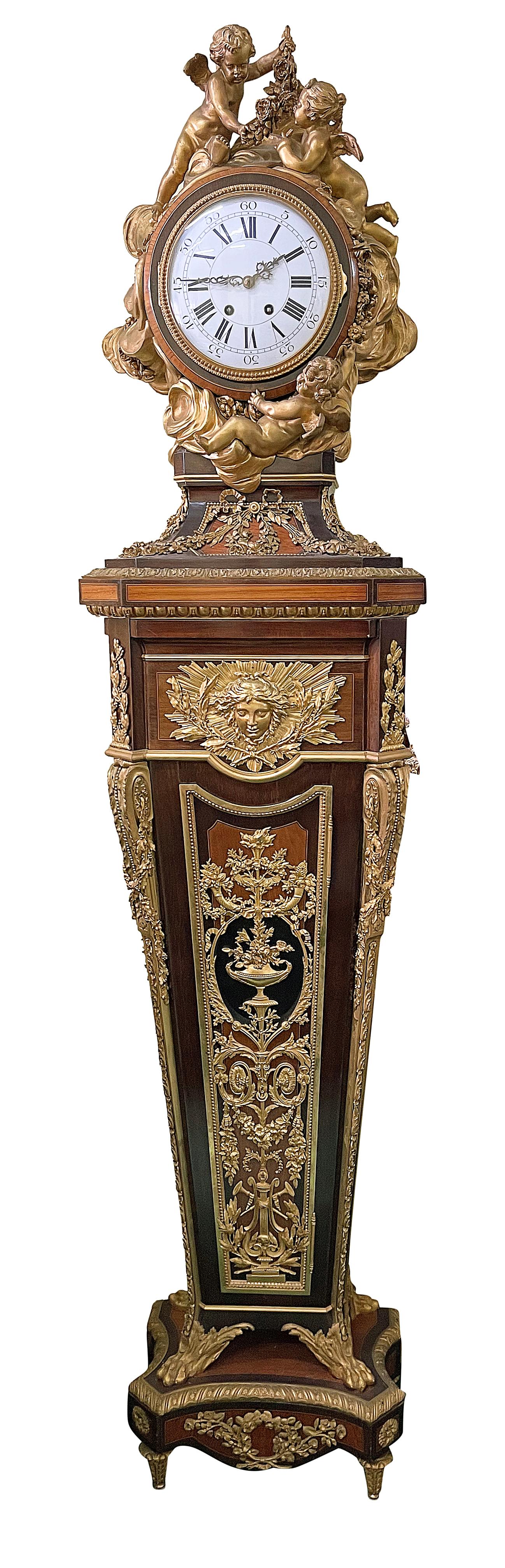 Questo squisito orologio a cassa lunga in stile Luigi XV francese del XIX secolo presenta intricate montature in ormolu che ne evidenziano l'eleganza. Adornato con motivi floreali finemente dettagliati e figure di cherubini, l'orologio mostra