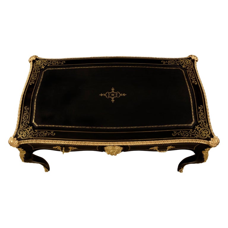 A striking French 19th Century Louis XV st. Napoleon III period ebony, brass inlaid and ormolu mounted Boulle desk. The two drawer desk is raised by cabriole legs elegantly decorated by ormolu chutes leading to the bottom ormolu pierced sabots. The