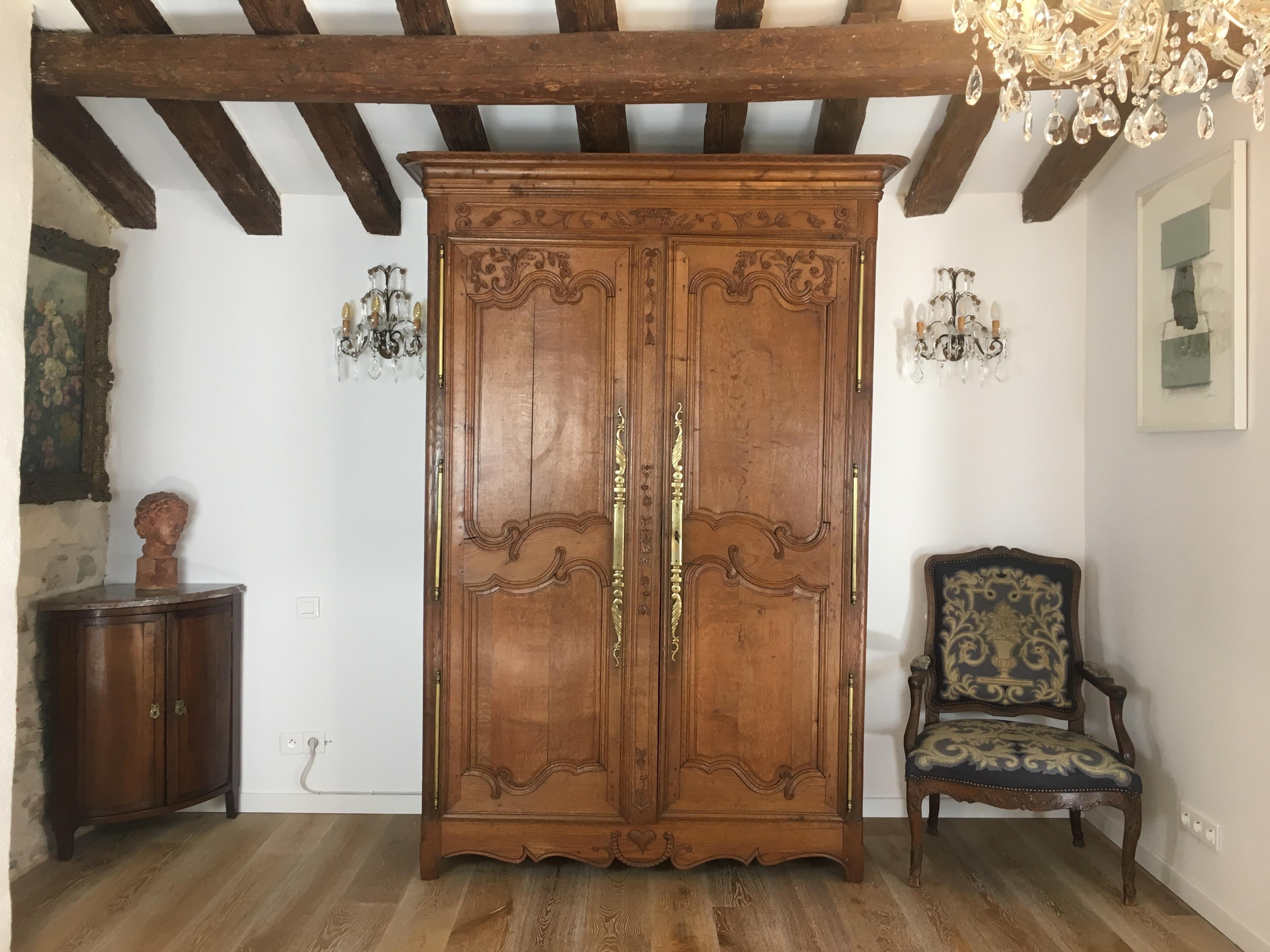 Steeped in history, this captivating French 19th Century Louis XV Style Wedding Armoire from Normandy is crafted from warm French white oak, embodies the charm of the Louis XV style.

The ornately carved frieze and raised panels showcase a graceful