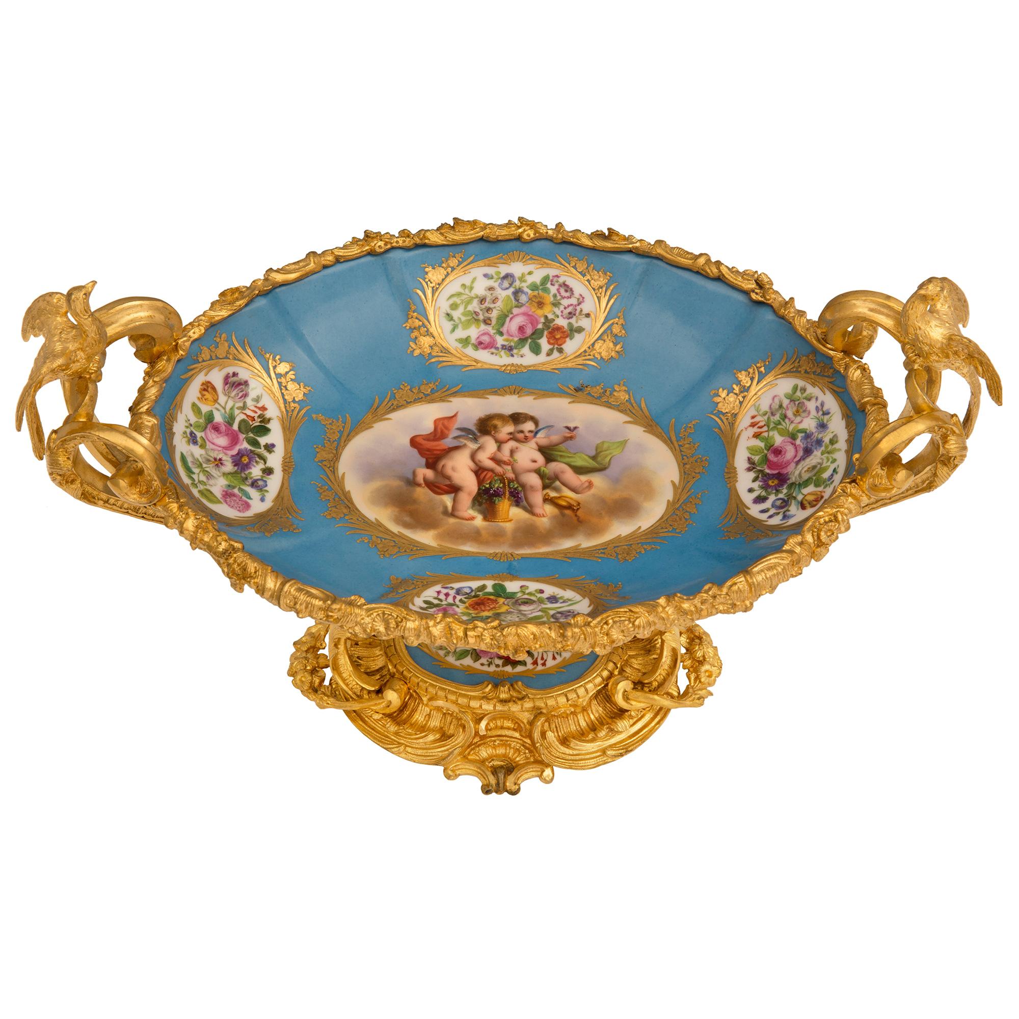 An elegant French 19th century Louis XV st. ormolu and Sèvres porcelain centerpiece. The centerpiece is raised by an exquisite oval shaped ormolu base with richly chased seashells and beautiful foliate movements in a satin and burnished finish. The