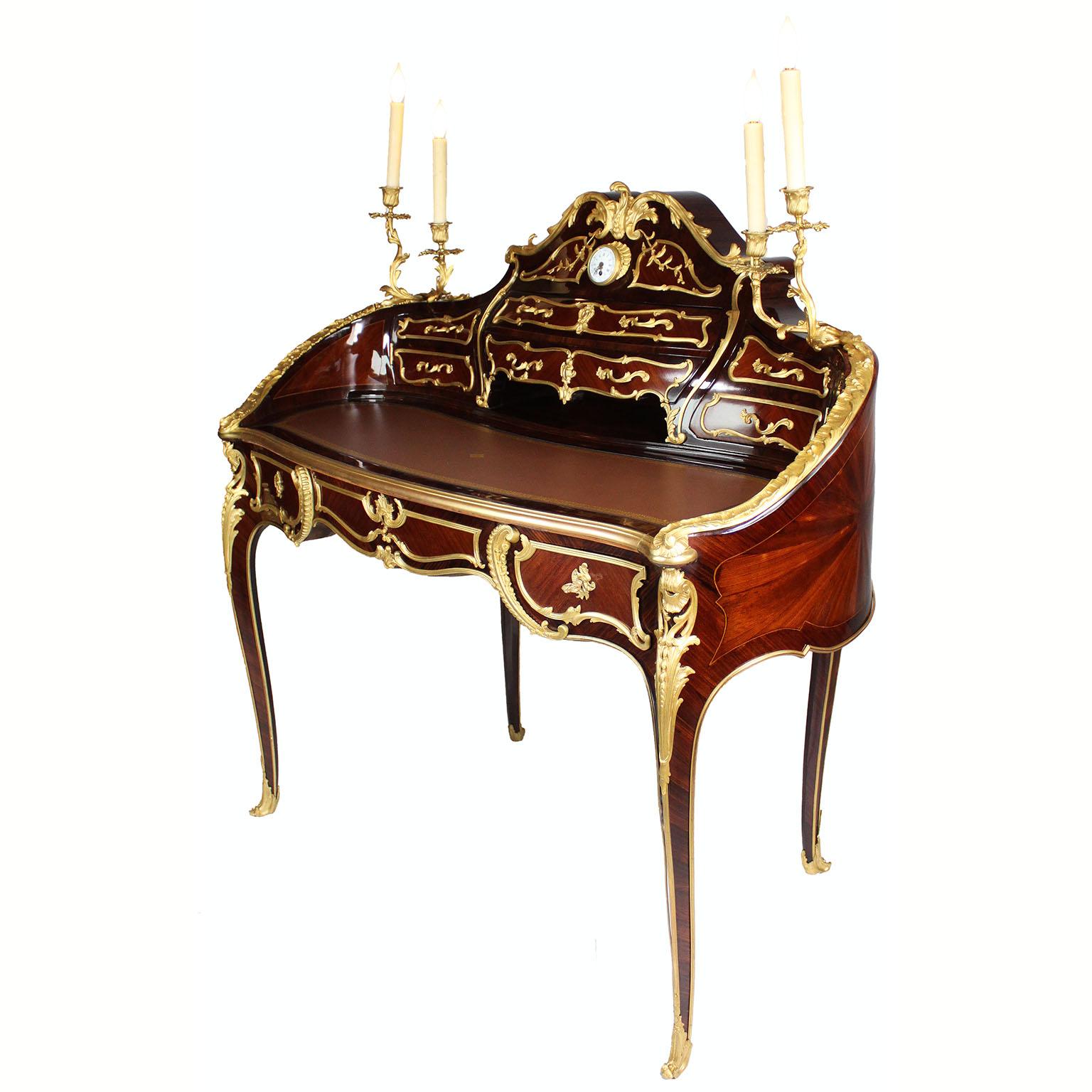 Un raffinato secrétaire de dame francese del XIX secolo in stile Luigi XV, montato in legno di rena, legno di raso e intarsio di frutta, con orologio a quadrante smaltato e candelabri, attribuito a Théodore Millet 