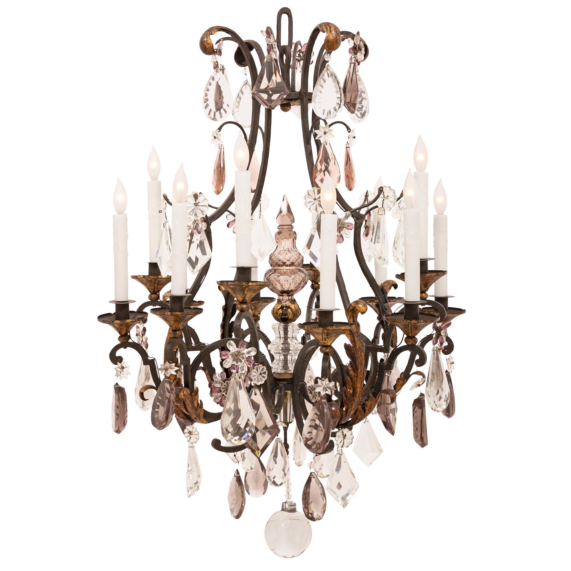 An elegant and most charming French 19th century Louis XV st. Baccarat crystal, patinated and gilt iron chandelier. The twelve arm chandelier is centered by an impressive solid smooth crystal ball amidst an array of exquisite clear and amethyst