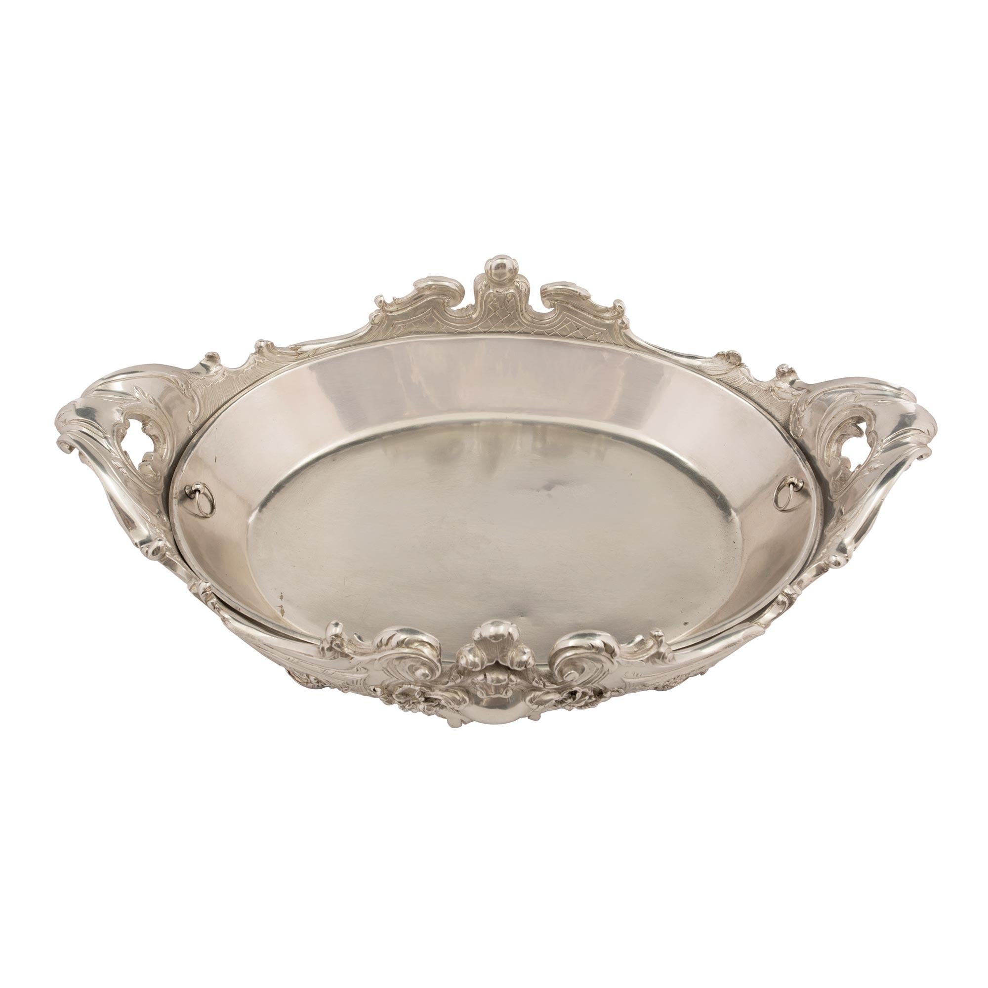 A superb French 19th century Louis XV st. silvered bronze centerpiece with its original removable interior. The centerpiece is raised by elegant scrolled foliate feet. The body displays a beautiful and most decorative scalloped shape with fine