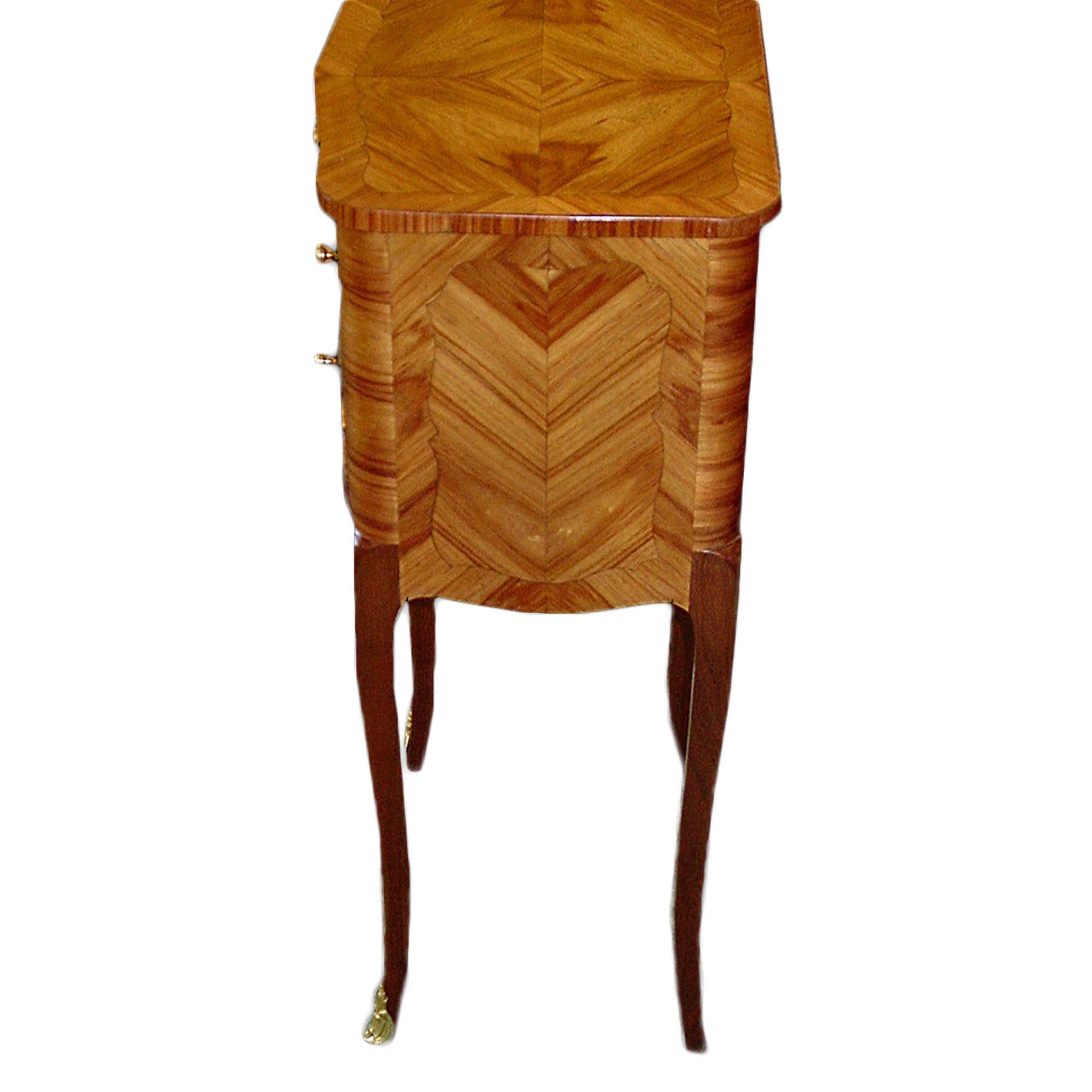 A charming French 19th century Louis XV St. three drawer side table. The table in tulipwood has quarter veneered sides and top. The whole is raised on elegant slender cabriole legs decorated with ormolu sabots while the drawers have ormolu drawer