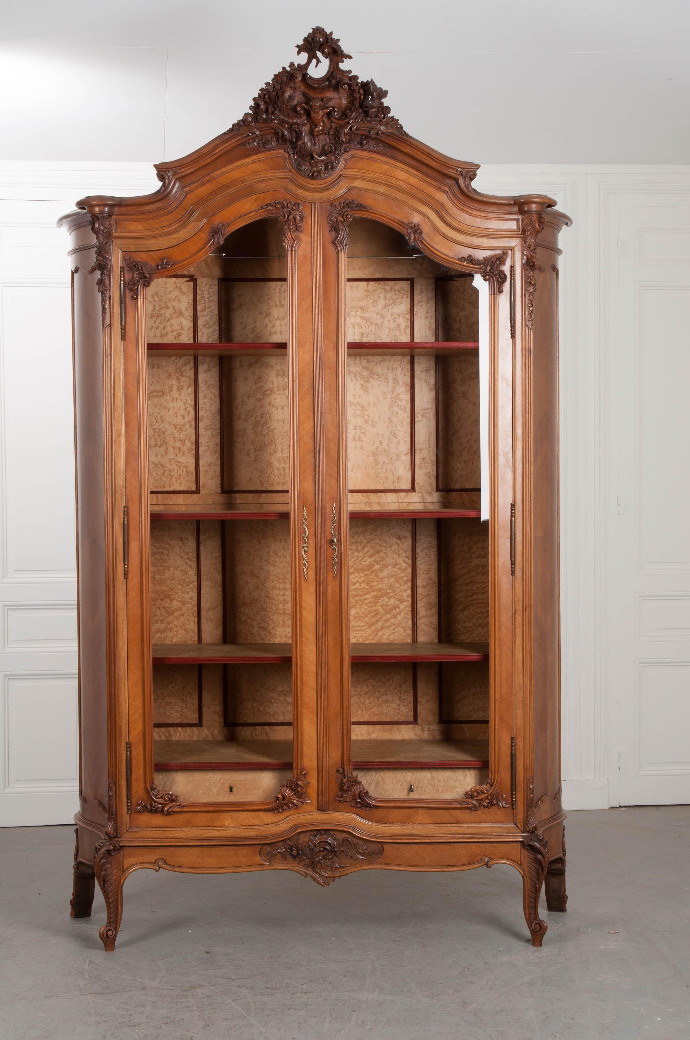 An exceptionally well-carved Louis XV style armoire from 1880s, France. The crest atop the armoire is masterfully worked, with carved and pierced details in the form of a cherub between carved “C” scrolls, floral, foliate and bird motifs. This crest