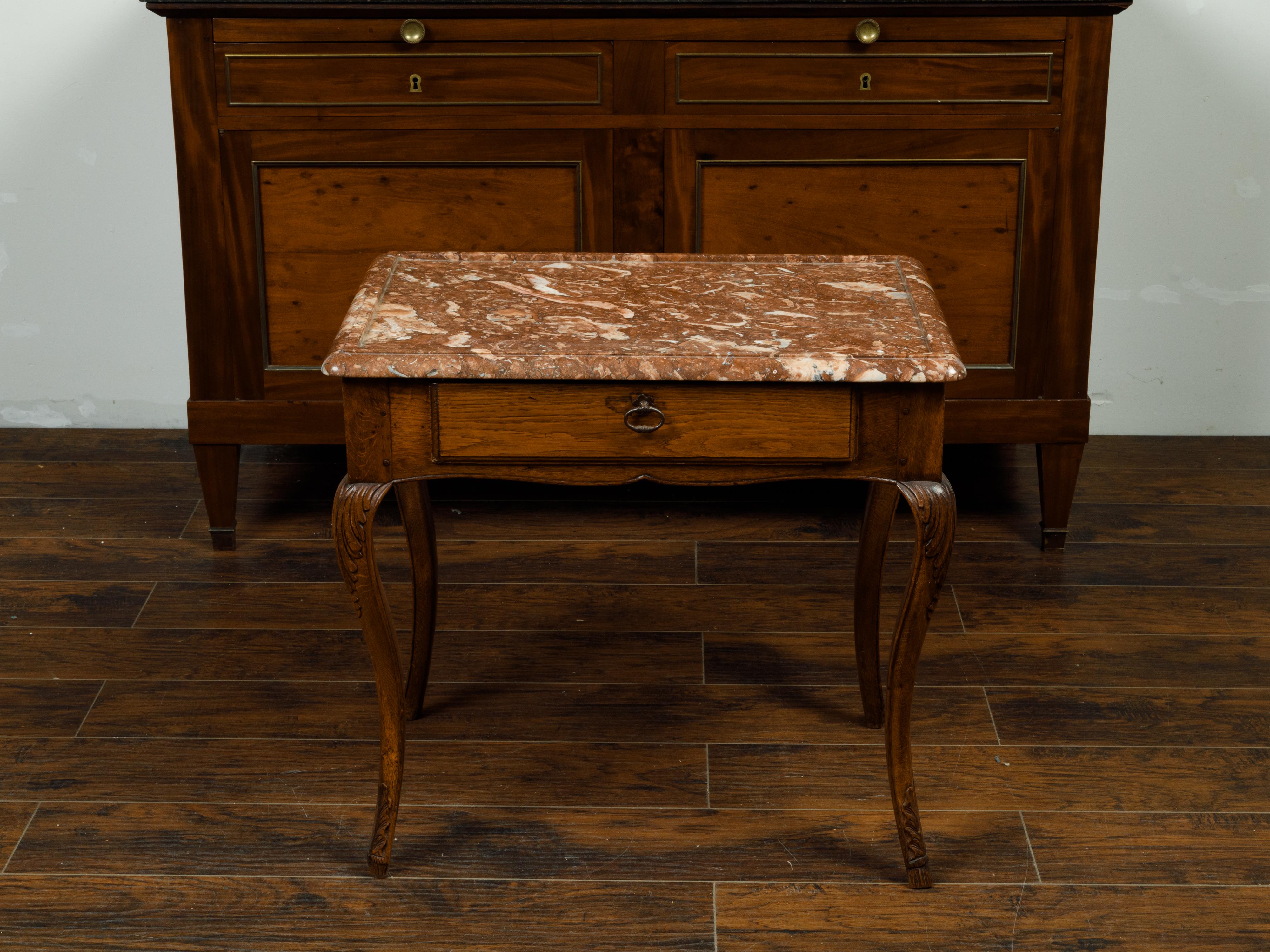 A French Louis XV style walnut side table from the 19th century, with red marble top, single drawer and cabriole legs. Created in France during the 19th century, this walnut side table features a rectangular variegated red marble top recessed in the