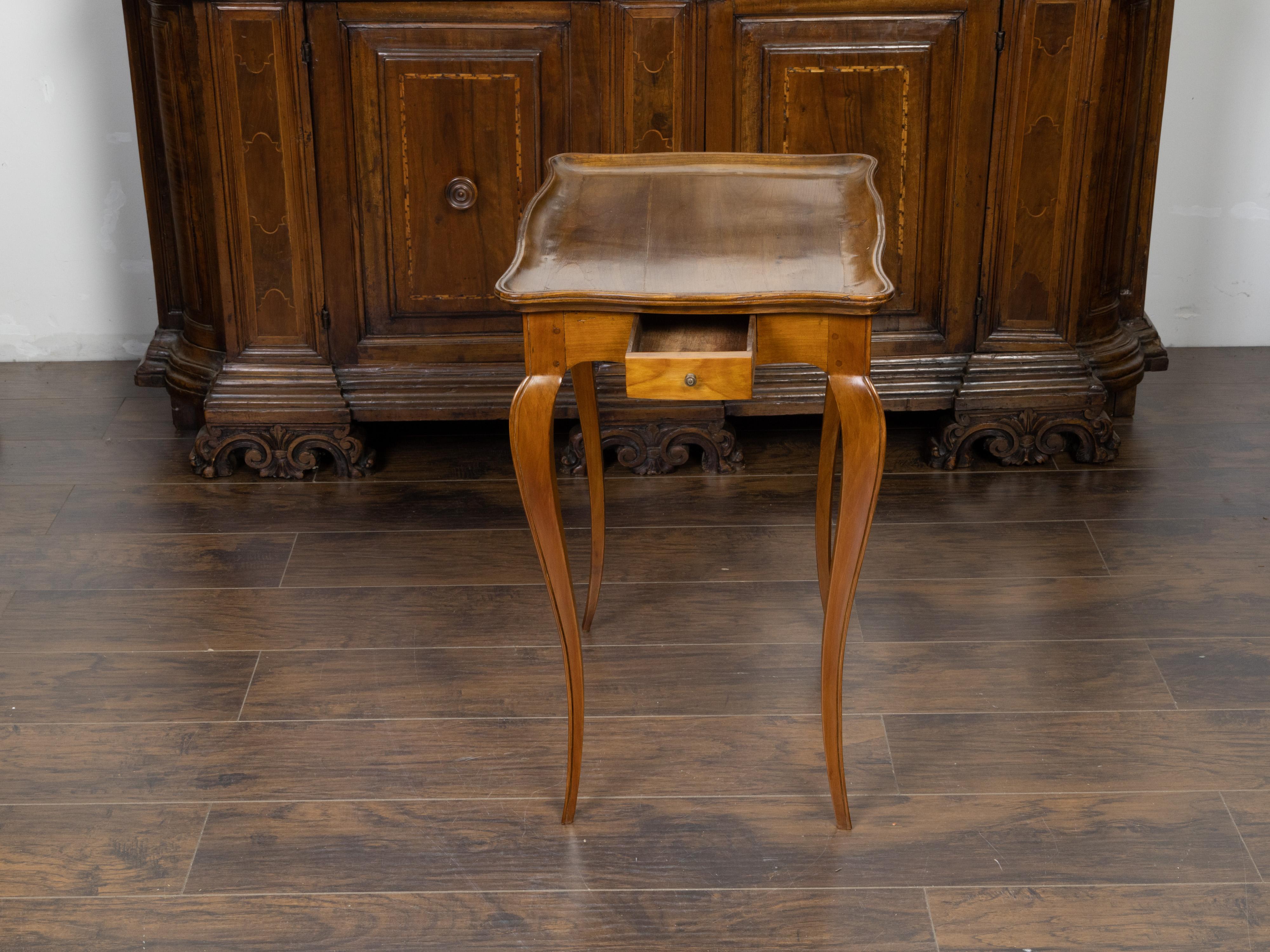 A French Louis XV style walnut side table from the 19th century, with tray top, single drawer and cabriole legs. Created in France during the 19th century, this walnut side table features a serpentine tray top sitting above a simple apron concealing