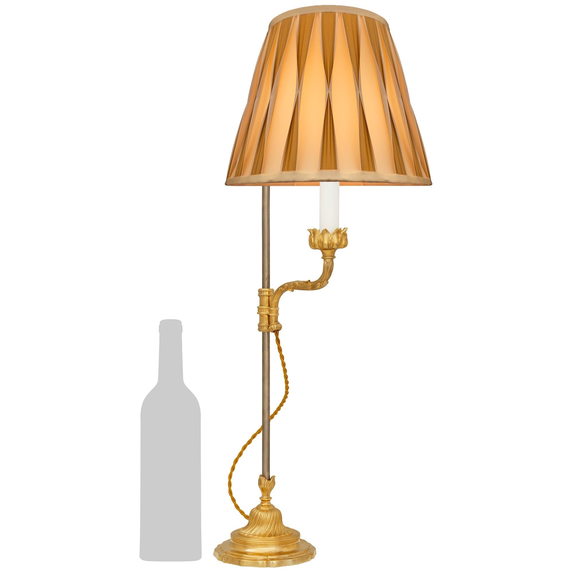 Elegante y singular lámpara francesa de Ormolu del siglo XIX, estilo Luis XV/XVI, firmada Gagneau Paris. Esta rara lámpara se alza sobre una base circular festoneada de Ormolu con el borde exterior moteado bajo el zócalo de diseño acanalado en