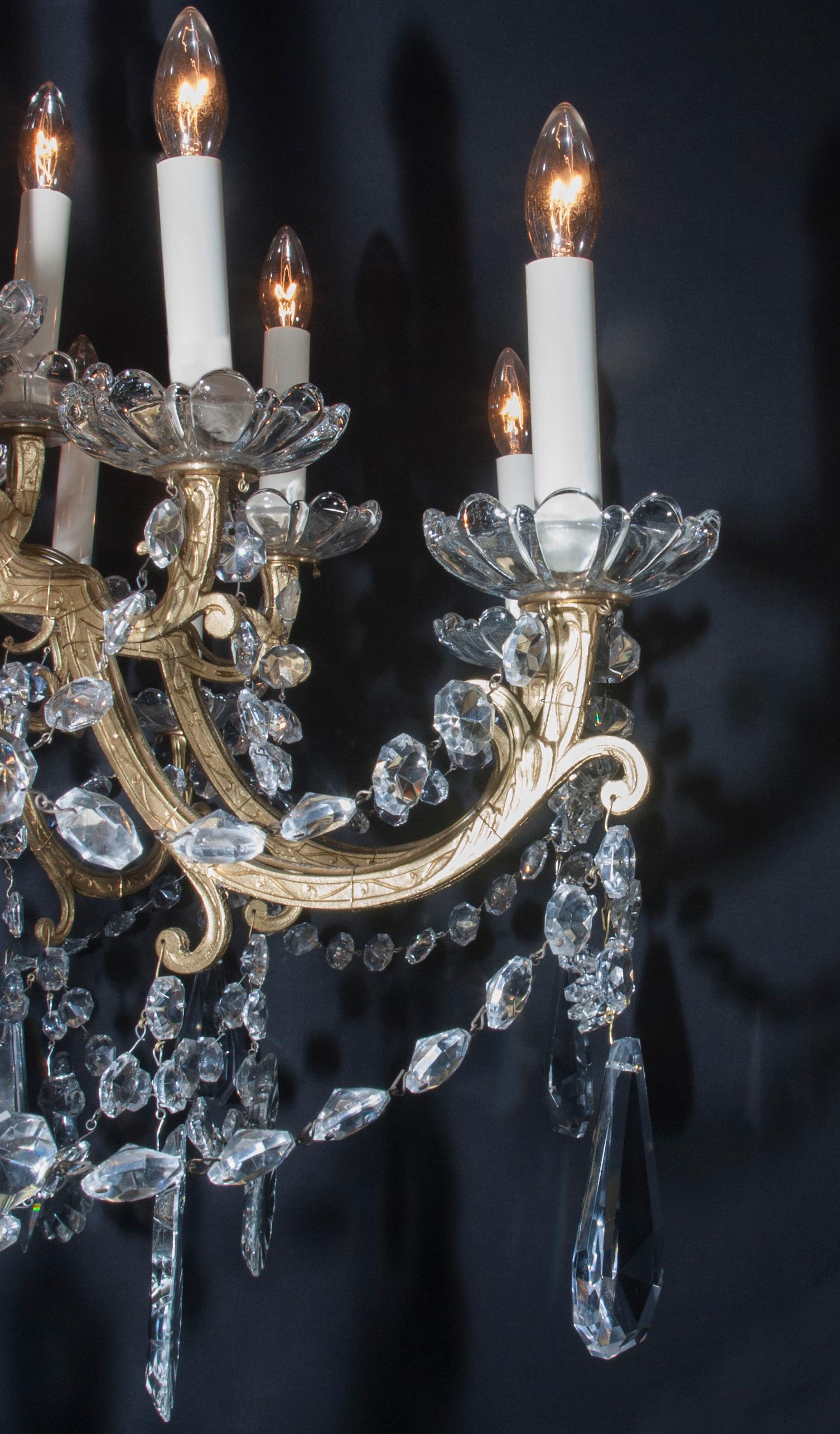 Questo lampadario classico Luigi XVI risale al XIX secolo ed è caratterizzato da splendidi livelli di cristallo che circondano il gambo centrale a spirale in bronzo. Le placchette di cristallo e il cristallo a forma ottagonale formano una corona