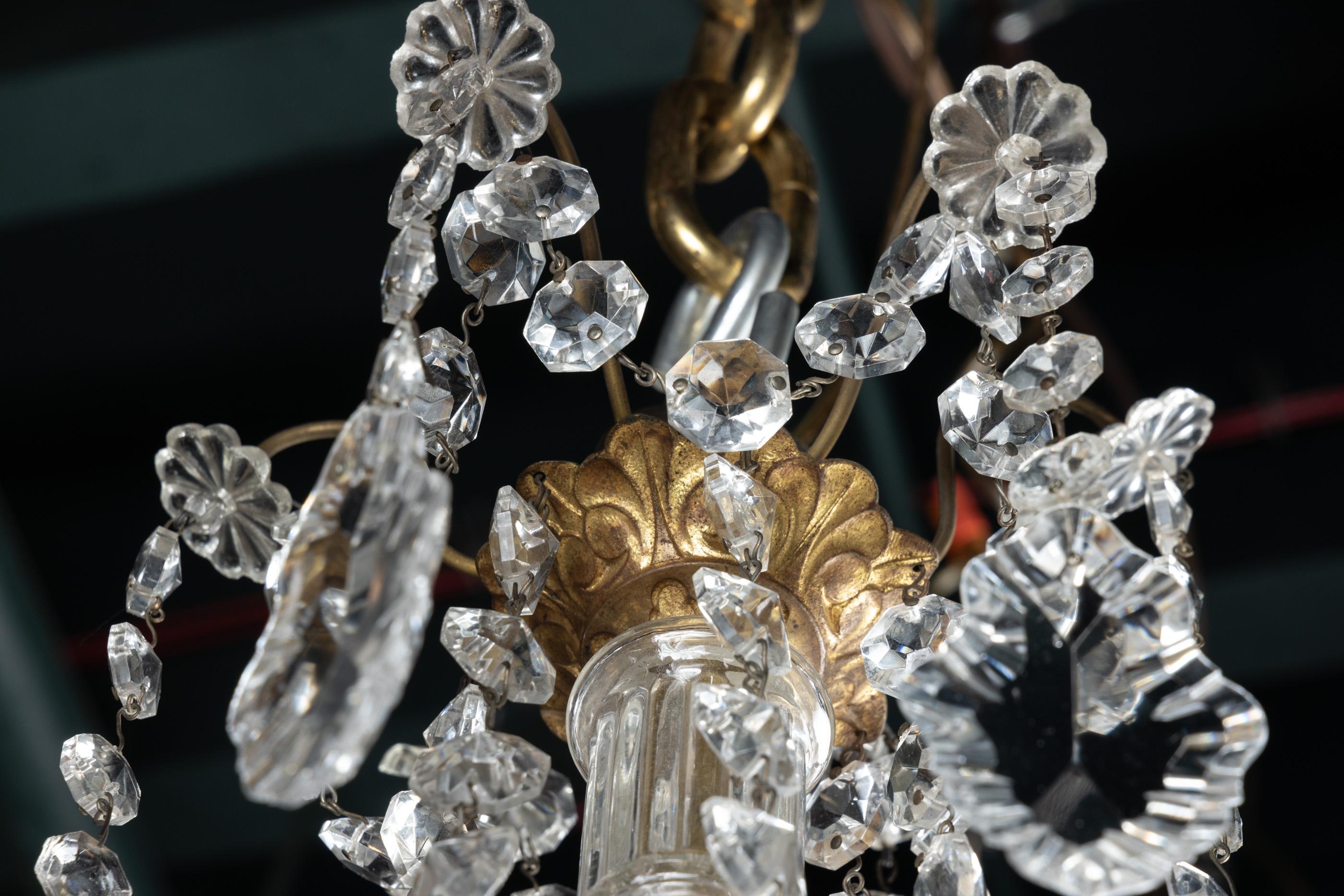 Lampadario francese del XIX secolo Luigi XVI a un piano in bronzo drappeggiato con corde di cristalli tagliati a ottagono, centro in cristallo, plaquettes e bobeches in cristallo. Il pezzo è dotato di sei luci