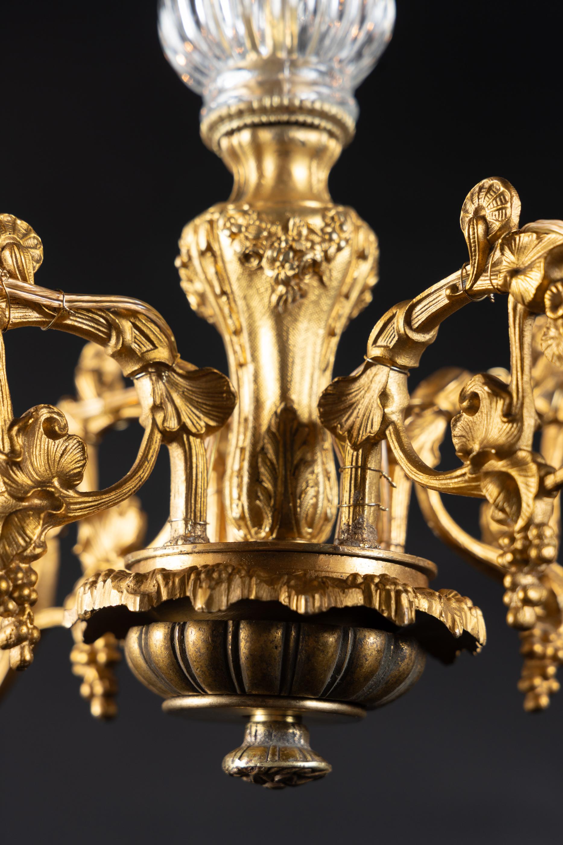 French 19th century Louis XVI Bronze d’ore chandelier with cut crystal bobeches. The piece features an ornate crown at top and finely detailed arms. The cut crystal bobeches match the beautiful fluted crystal center stem.

Each piece in our shop is