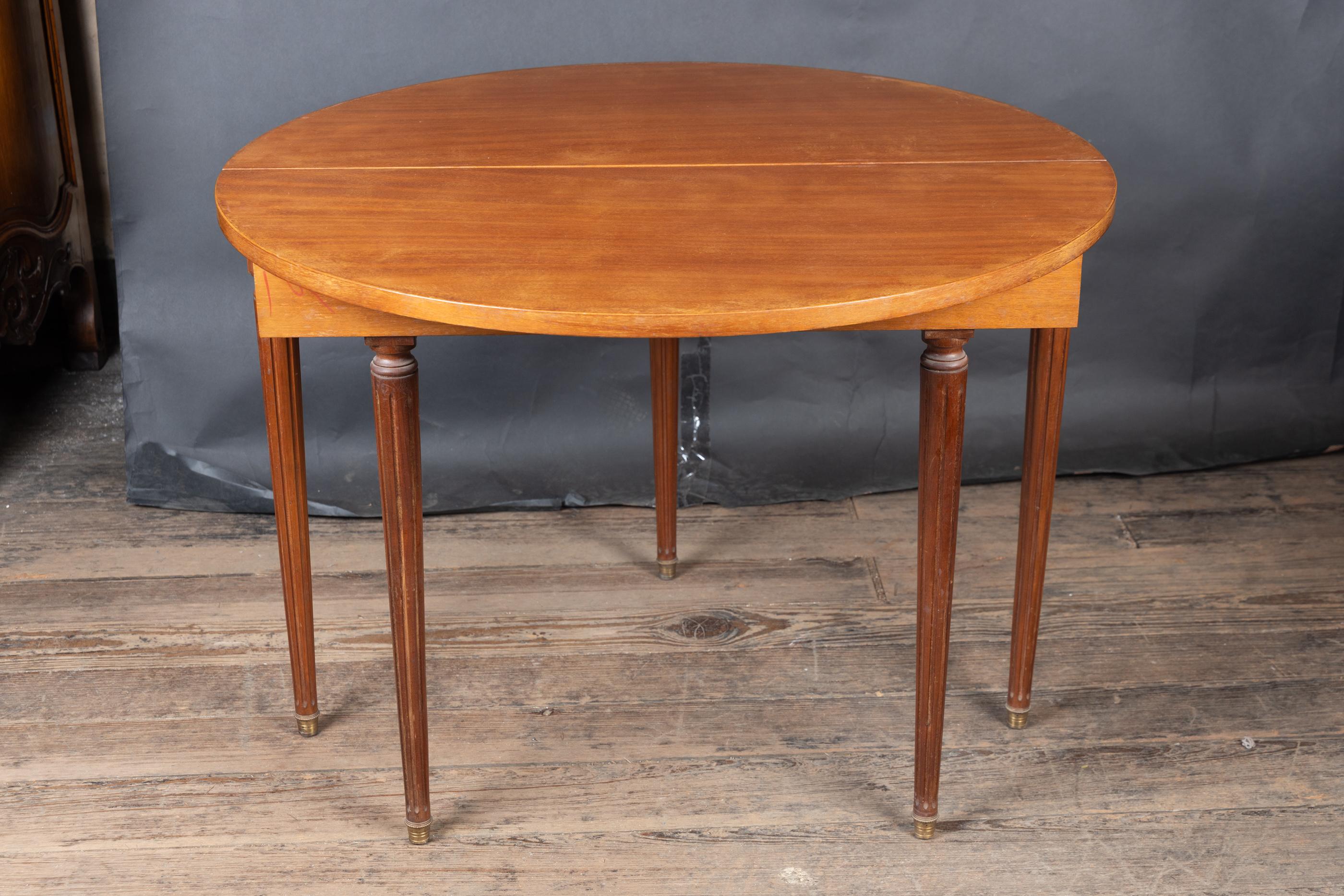 Table à cartes en demi-lune en bois fruitier de style Louis XVI du 19e siècle, à pieds cannelés. La pièce présente de belles et simples incrustations de bronze le long du tablier et des pieds en bronze à la base de chaque jambe. Les pieds de la