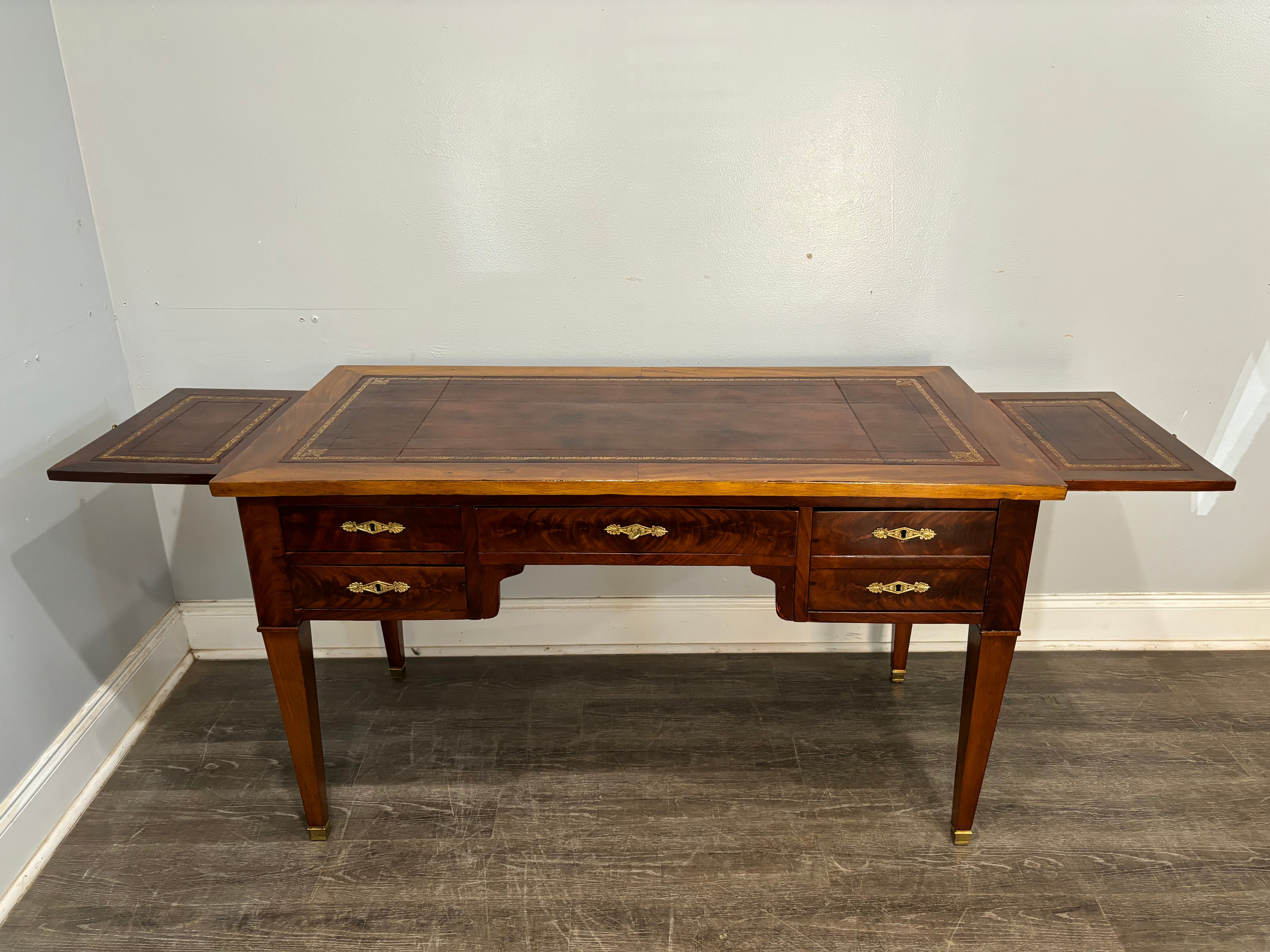This Louis XVI style Desk is made of mahogany and a wonderful brown  leather top which is in good condition. It has 2 extensions on each side. The length of the desk is 51.1''W and each extension is 12''W.
