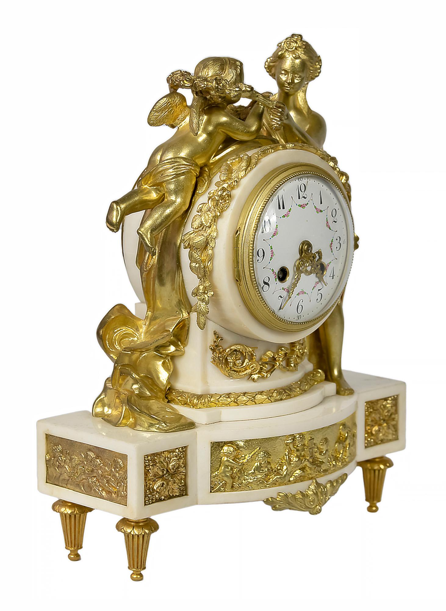 Pendule de cheminée ancienne en bronze doré et marbre blanc de style Louis XVI français du XIXe siècle.
Le boîtier circulaire est décoré d'éléments floraux et surmonté des figures de Vénus et de Cupidon.
Le cadran est en chiffres arabes sur plaque