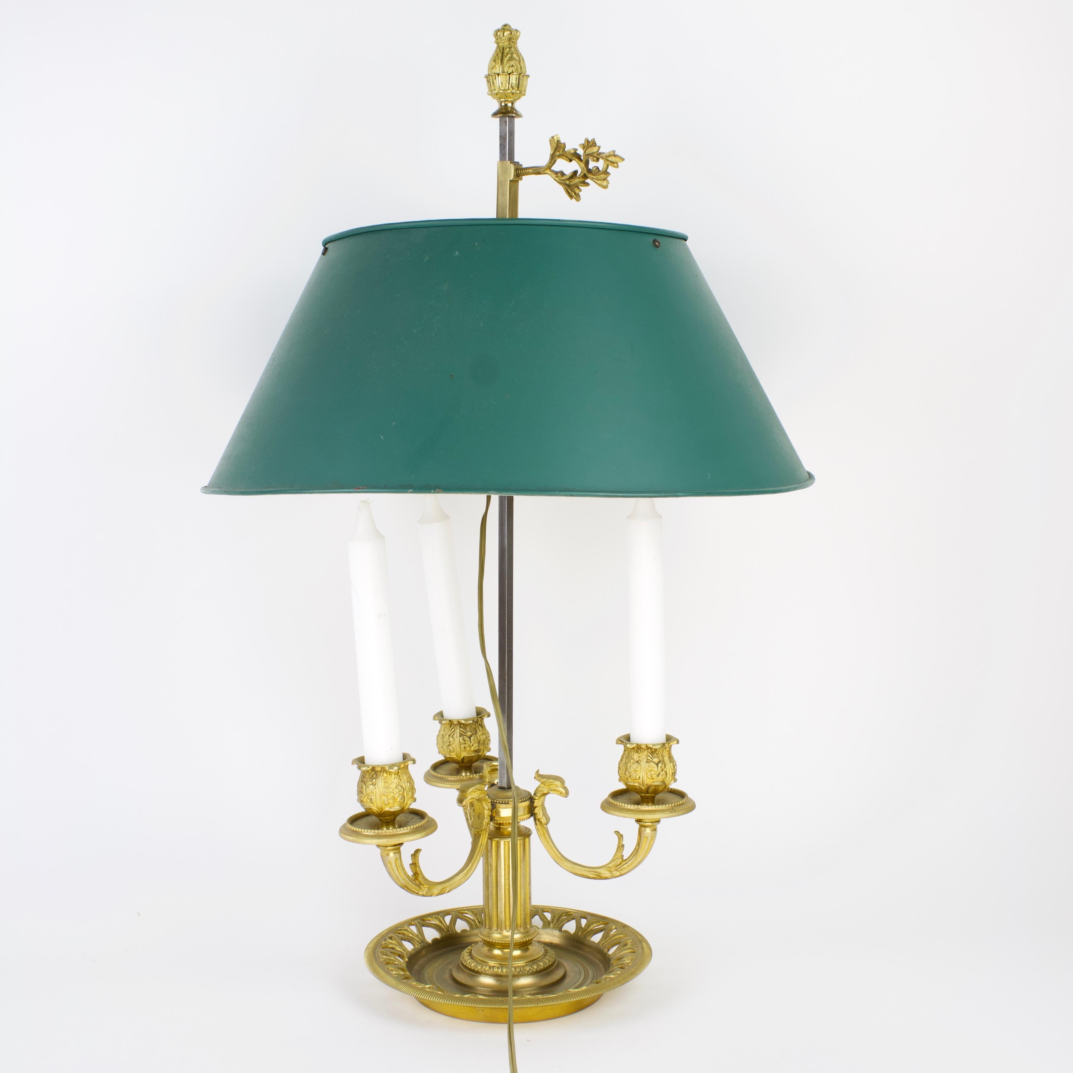 French 19th Century Louis XVI Gilt Bronze Bouillotte lamp

A 19th century Louis XVI style bouillotte lamp in green toleware and gilt bronze, with a circular stem supporting three scrolled foliate and eagle head candle branches, raised on a finely