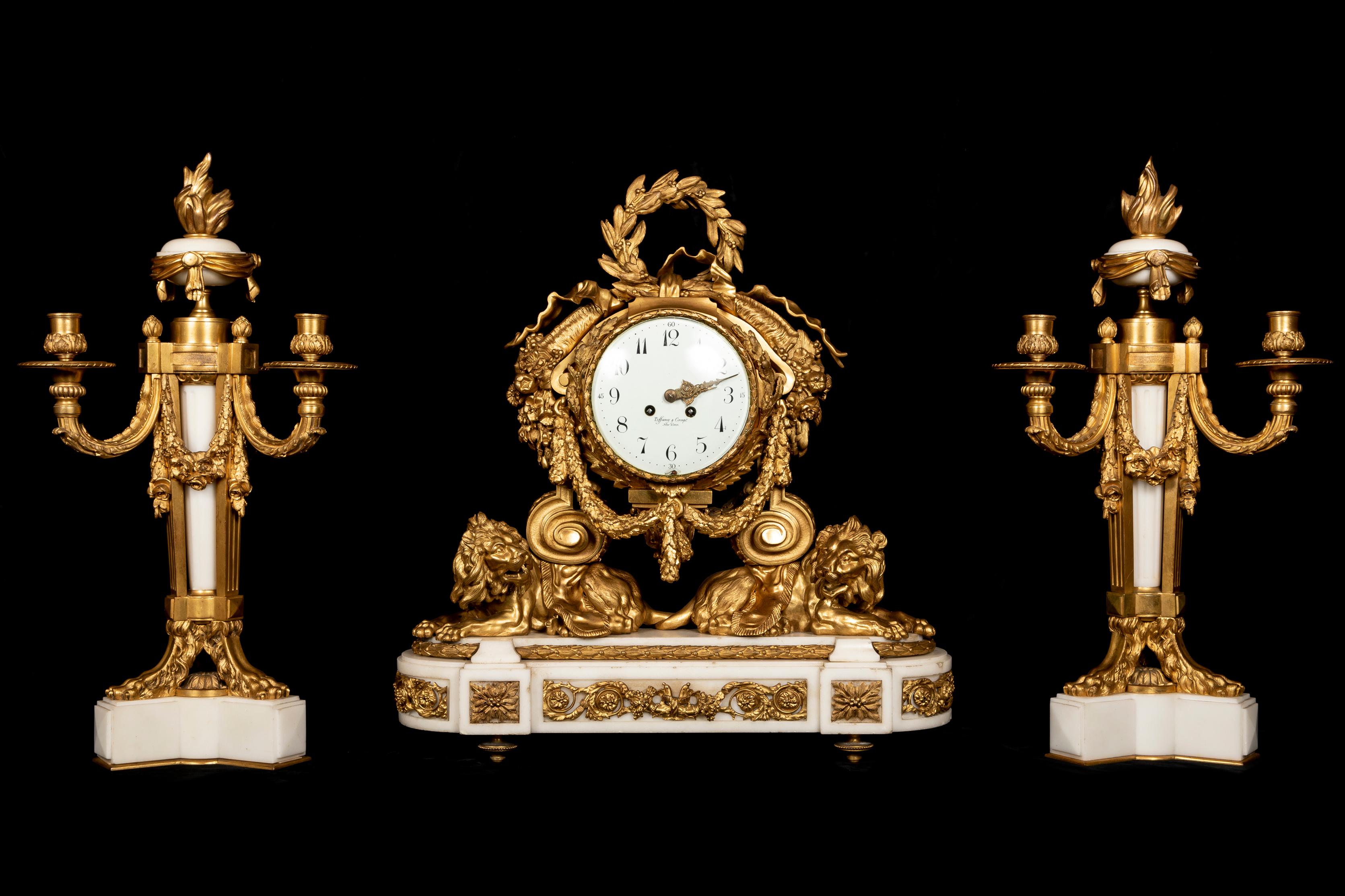 Exceptionnelle et suprêmement raffinée, cette grande pendule française de style Louis XVI en bronze doré et marbre blanc, datant du XIXe siècle et fièrement vendue par l'estimée maison Tiffany & Co. de New York, est élégamment inscrite sur le cadran