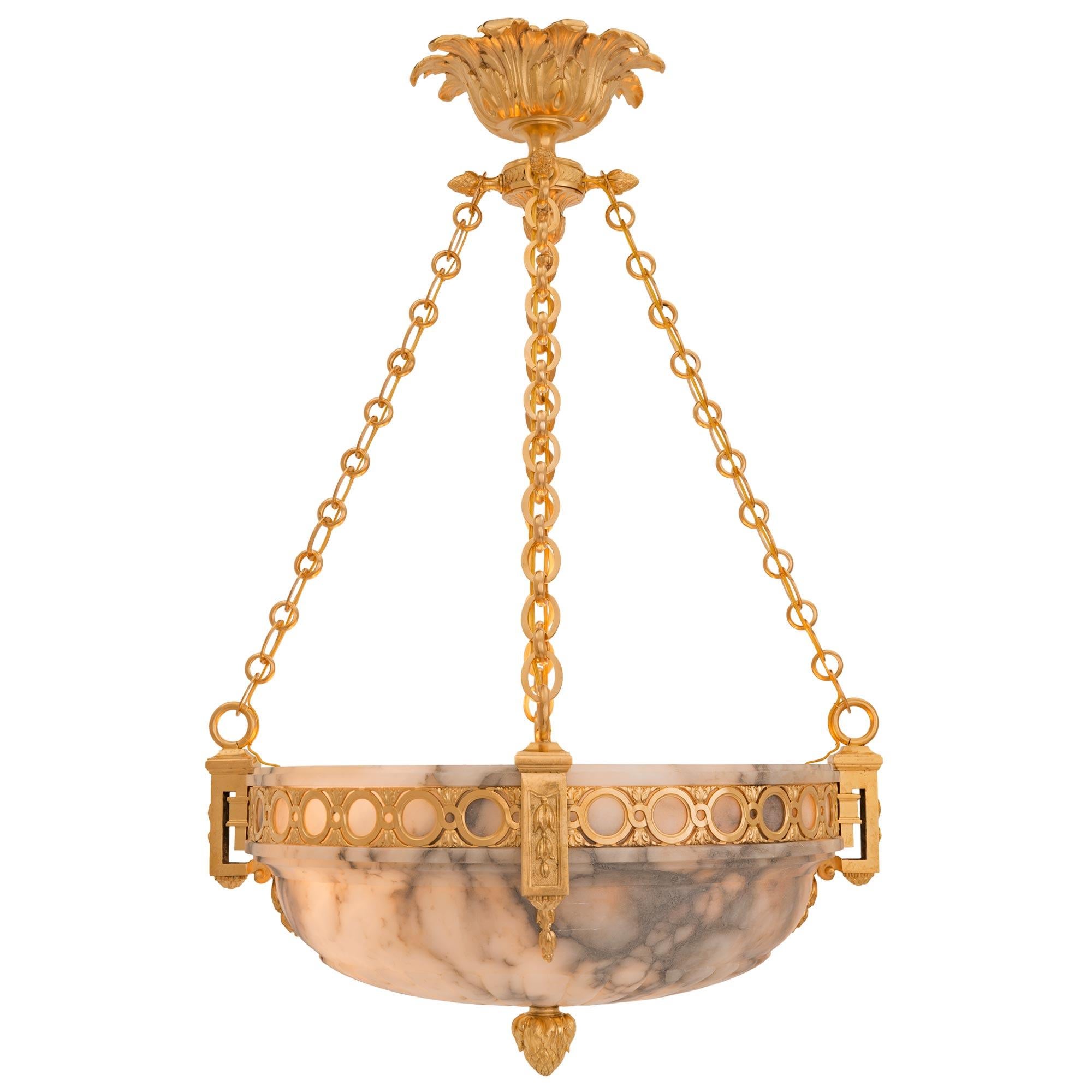 A stunning French 19th century Louis XVI st. alabaster and ormolu chandelier. The chandelier is centered by a richly chased acorn finial below the impressive alabaster bowl with a wonderfully sculpted reeded design. The bowl displays striking finely