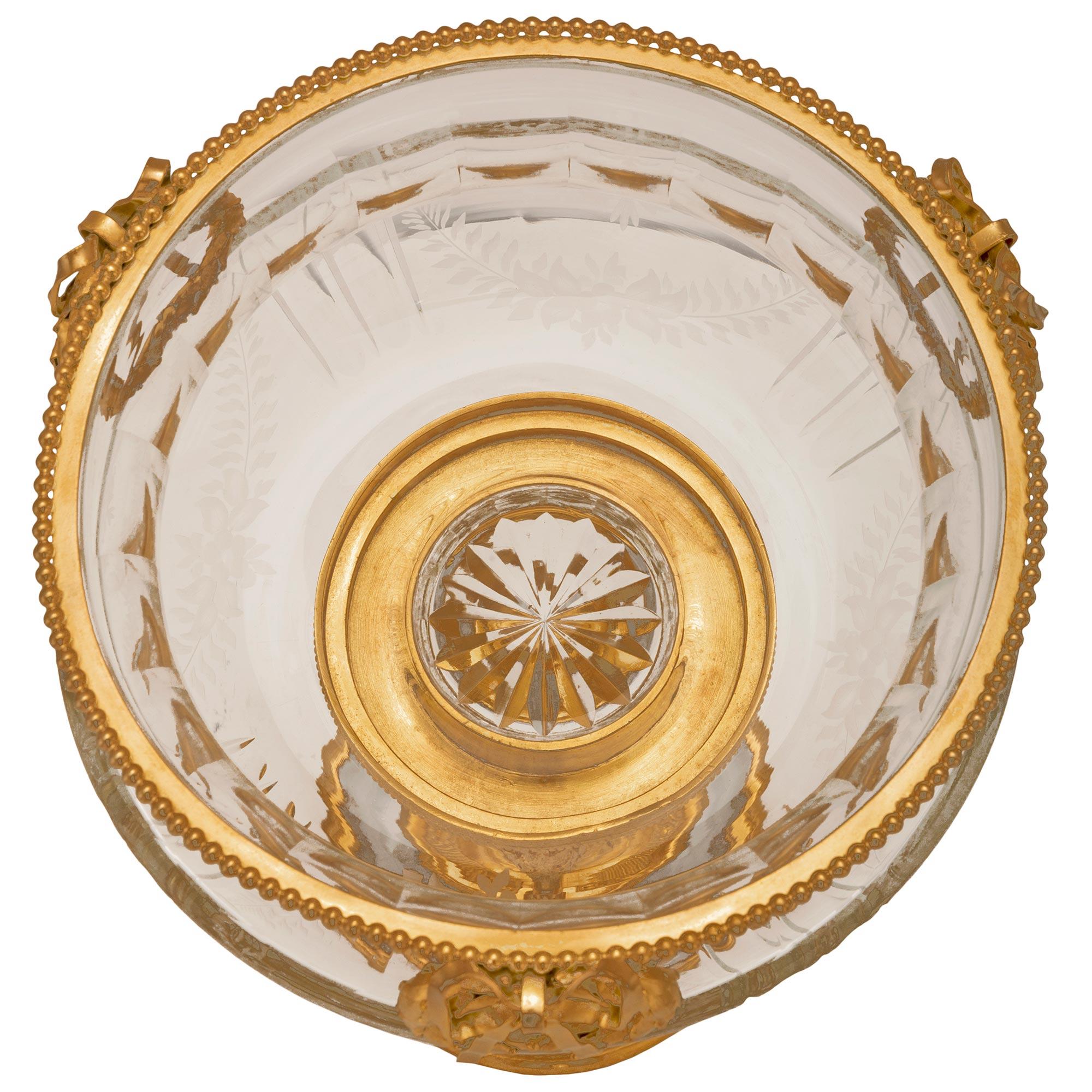 A beautiful and most elegant French 19th century Louis XVI st. Baccarat crystal and ormolu centerpiece. The centerpiece is raised by a circular base with lovely stepped mottled ormolu bands with Coeur de Rai, mottled, and beaded designs. Three