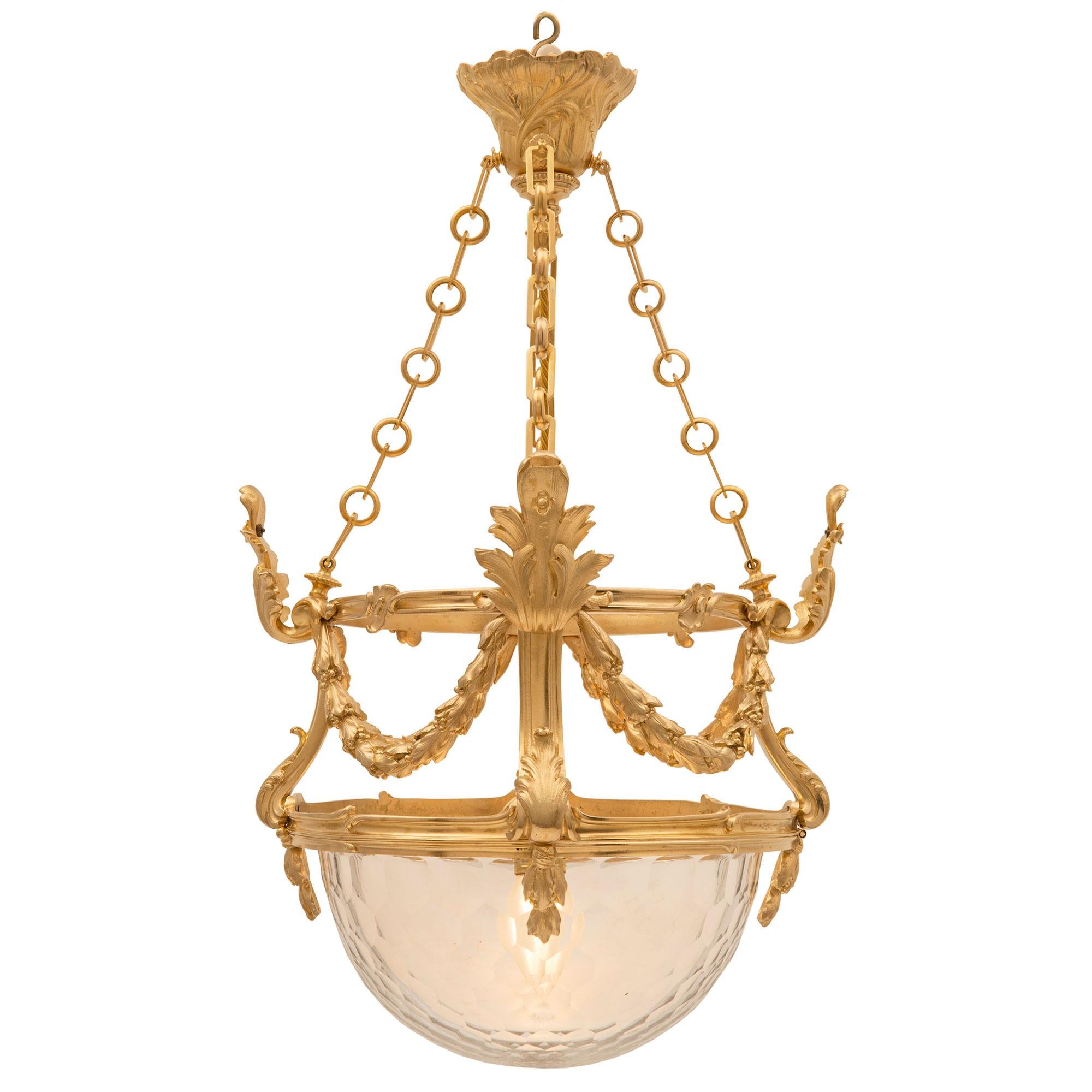A remarkable French 19th century Louis XVI st. Baccarat crystal and ormolu chandelier. The chandelier is centered by a most elegant Baccarat crystal bowl with a fine honeycomb cut design which opens downwards on its original hinges. Above the