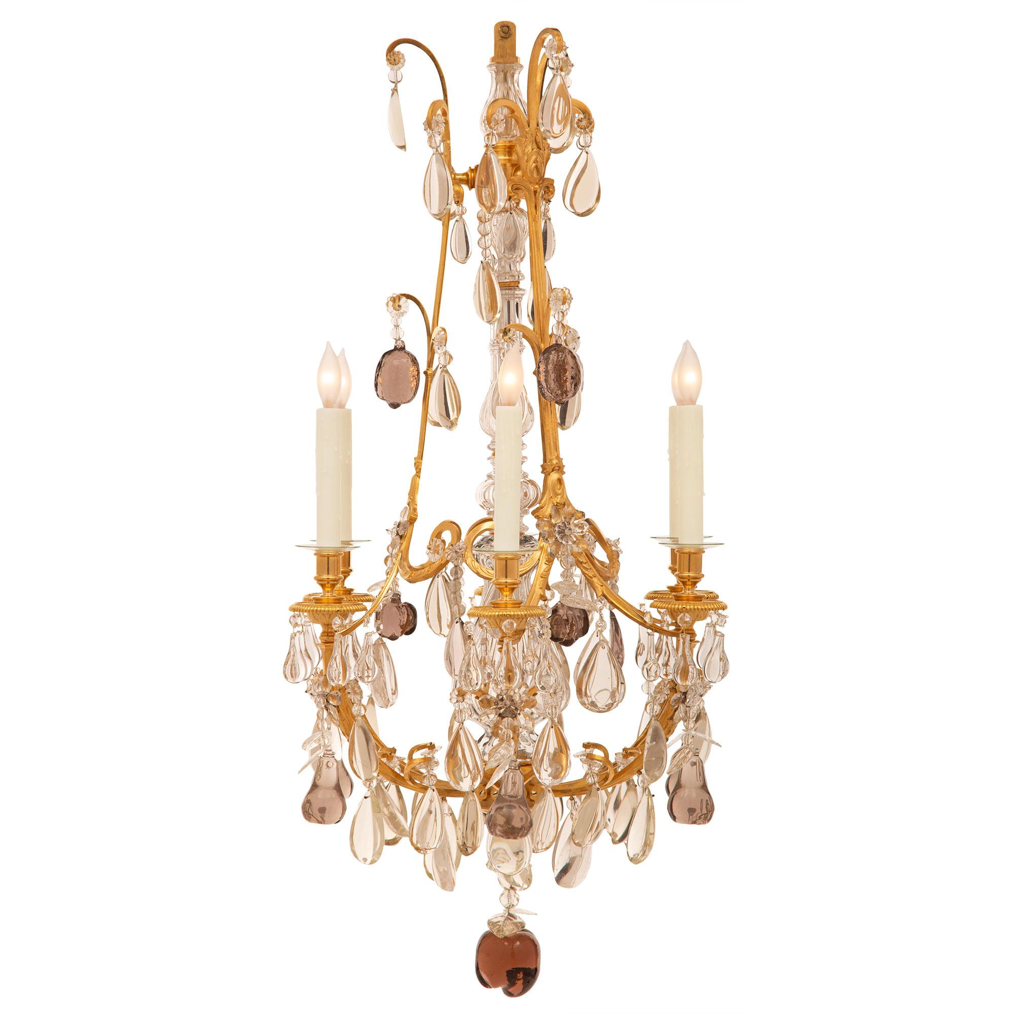 A striking and most decorative French 19th century Louis XVI st. Baccarat crystal, colored crystal, and ormolu chandelier. The six arm chandelier is centered by a beautiful and very unique caramel colored apple shaped crystal pedant with lovely