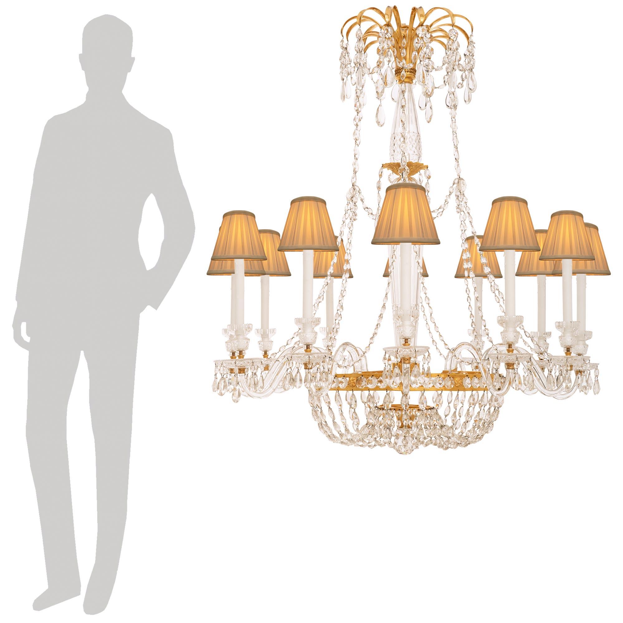 Uno squisito lampadario francese del XIX secolo St. Louis Crystal e Ormolu di grandi dimensioni. Questo straordinario lampadario a dodici bracci e quindici luci è centrato da un terminale inferiore in cristallo sferico finemente tagliato che si