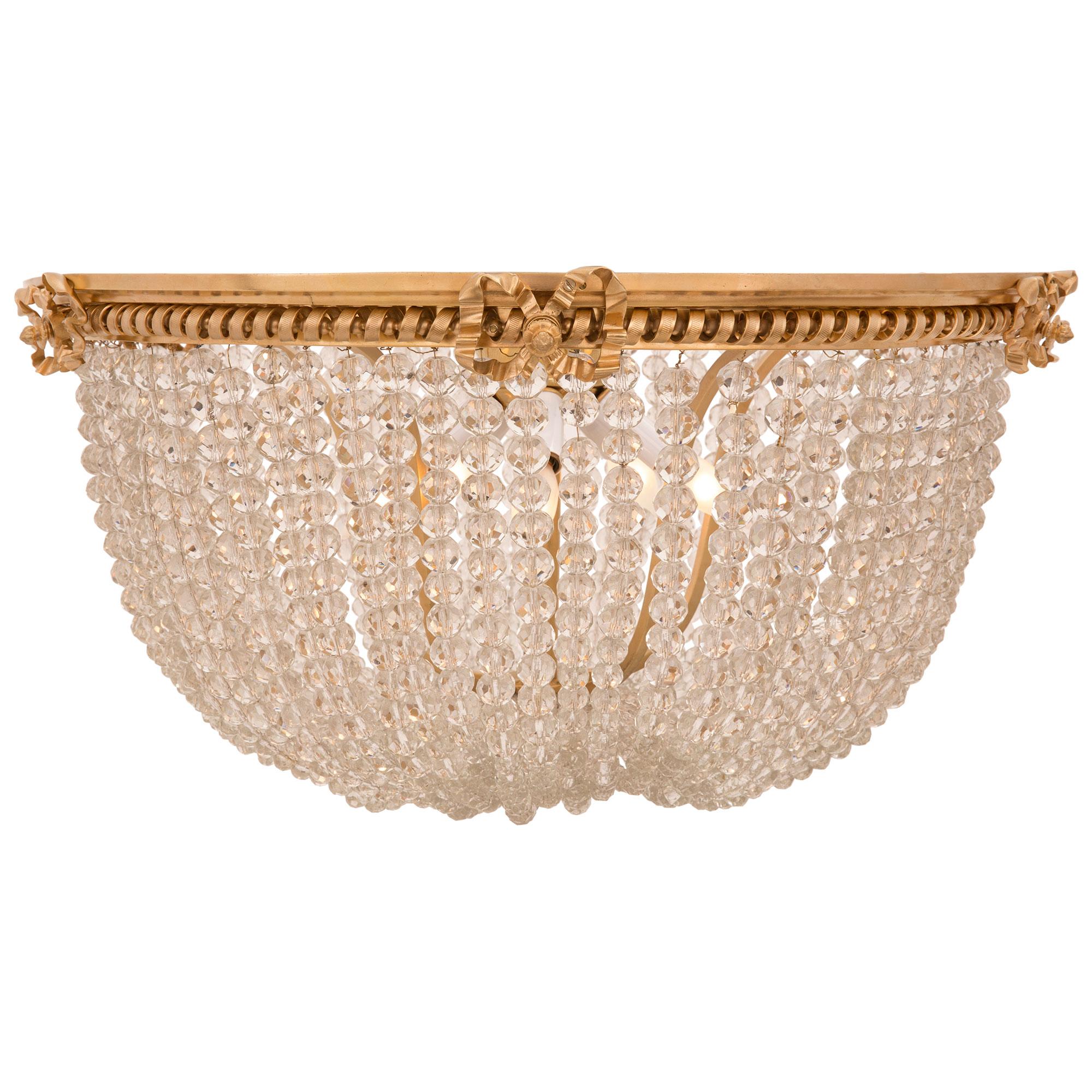 A most elegant French 19th century Louis XVI st. beaded glass and ormolu plafonnier chandelier. The chandelier is centered by a lovely bottom foliate ormolu finial from where the beautiful beaded glass garlands branch out. The garlands lead up to